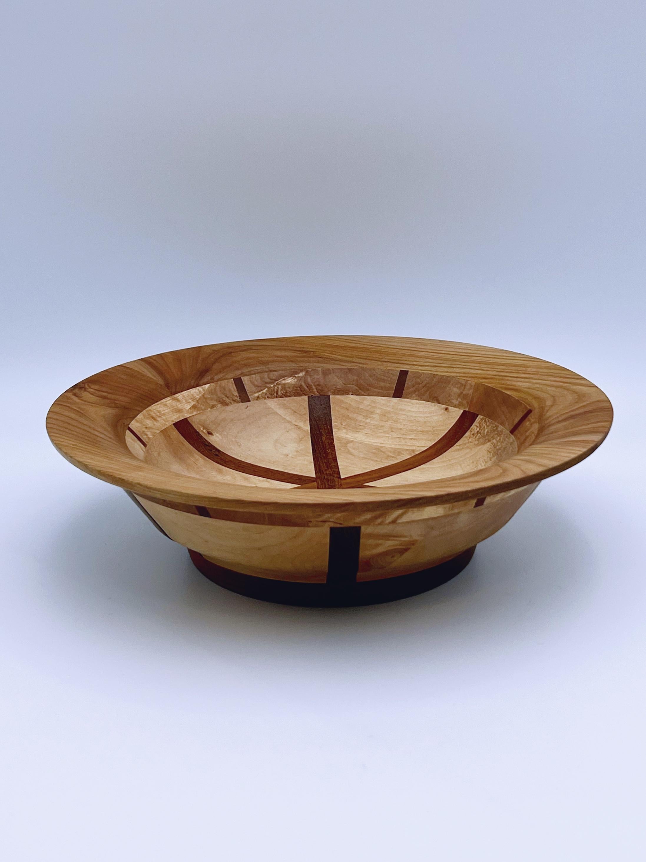 Diese atemberaubende skandinavische Schale im Mid-Century-Modern-Stil ist fachmännisch aus einer Kombination von Teakholz und möglicherweise Nussbaum gefertigt und weist ein auffälliges Kreuz- und geometrisches Muster auf. In den 1970er Jahren von