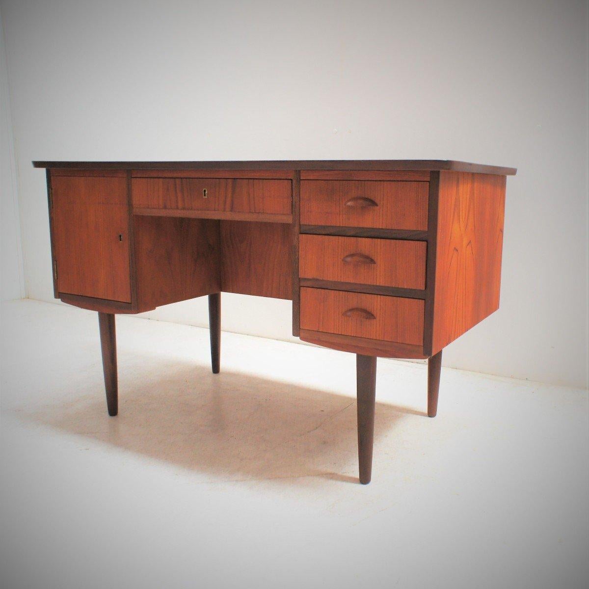 Vintage Scandinavian desk
Elegant Scandinavian desk. This desk, with a concave top, has two pedestals; one opening by a door, the other by three drawers, and a large frieze drawer. The visitor side has a storage niche with a mobile shelf. Key