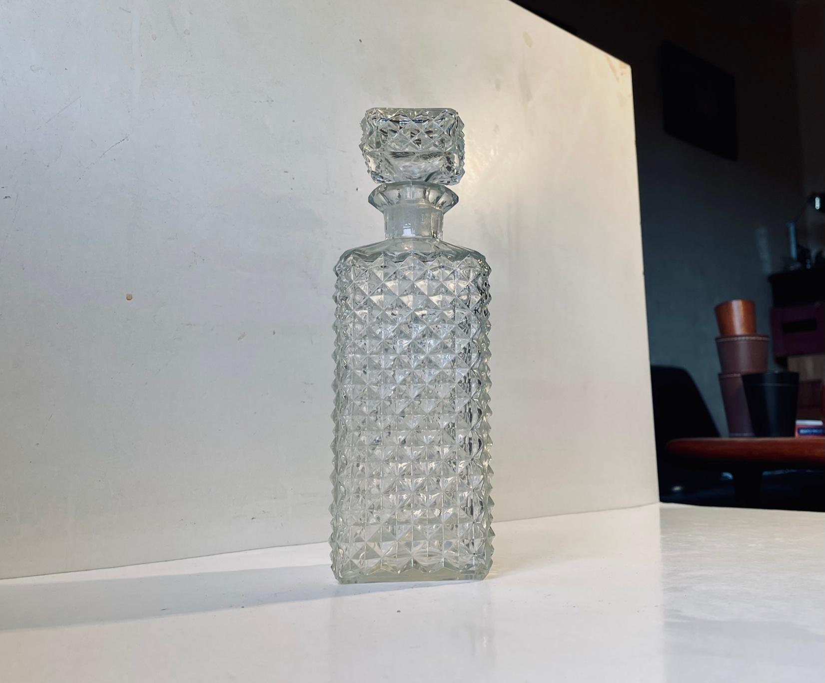 Une carafe en verre rectangulaire entièrement décorée de motifs en forme de diamant. Destiné au Whisky ou au Cognac. Design et fabricant scandinave anonyme, vers 1960. Capacité : environ 0,7 litre. Mesures : H : 25,5 cm.