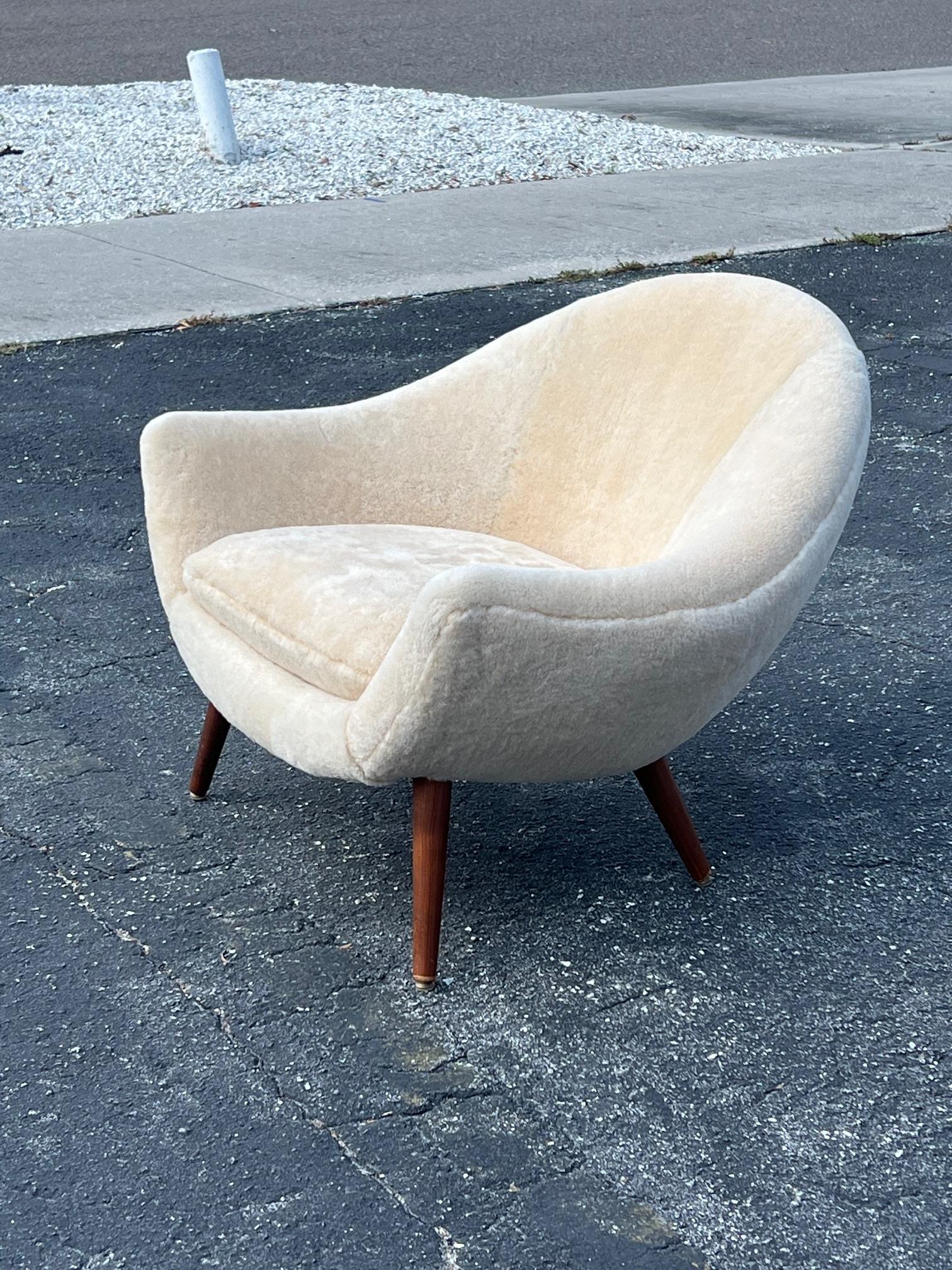 An unusual chair by Fredrik Kayser, Model No 860 for Vatne Lenestolfabrikk, Norway, ca' 1960's. Upholstered in natural Australian sheepskin. Legs are teak.