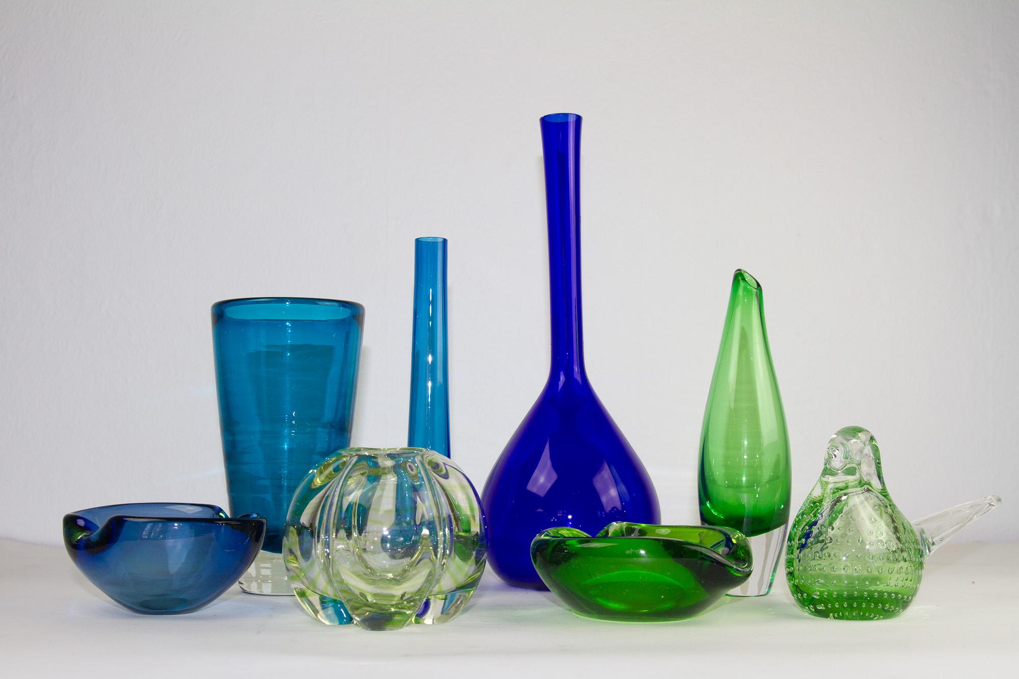 Vintage Scandinavian glass, 1960s. Set of 8. 
A collection of Scandinavian Modern multi colored glassware, primarily Danish.

This set consists of:
1 Tall blue bulb bud vase, height 31.5.
1 Teal blue bulb bud vase, height 21.5 cm.
1 Holmegaard