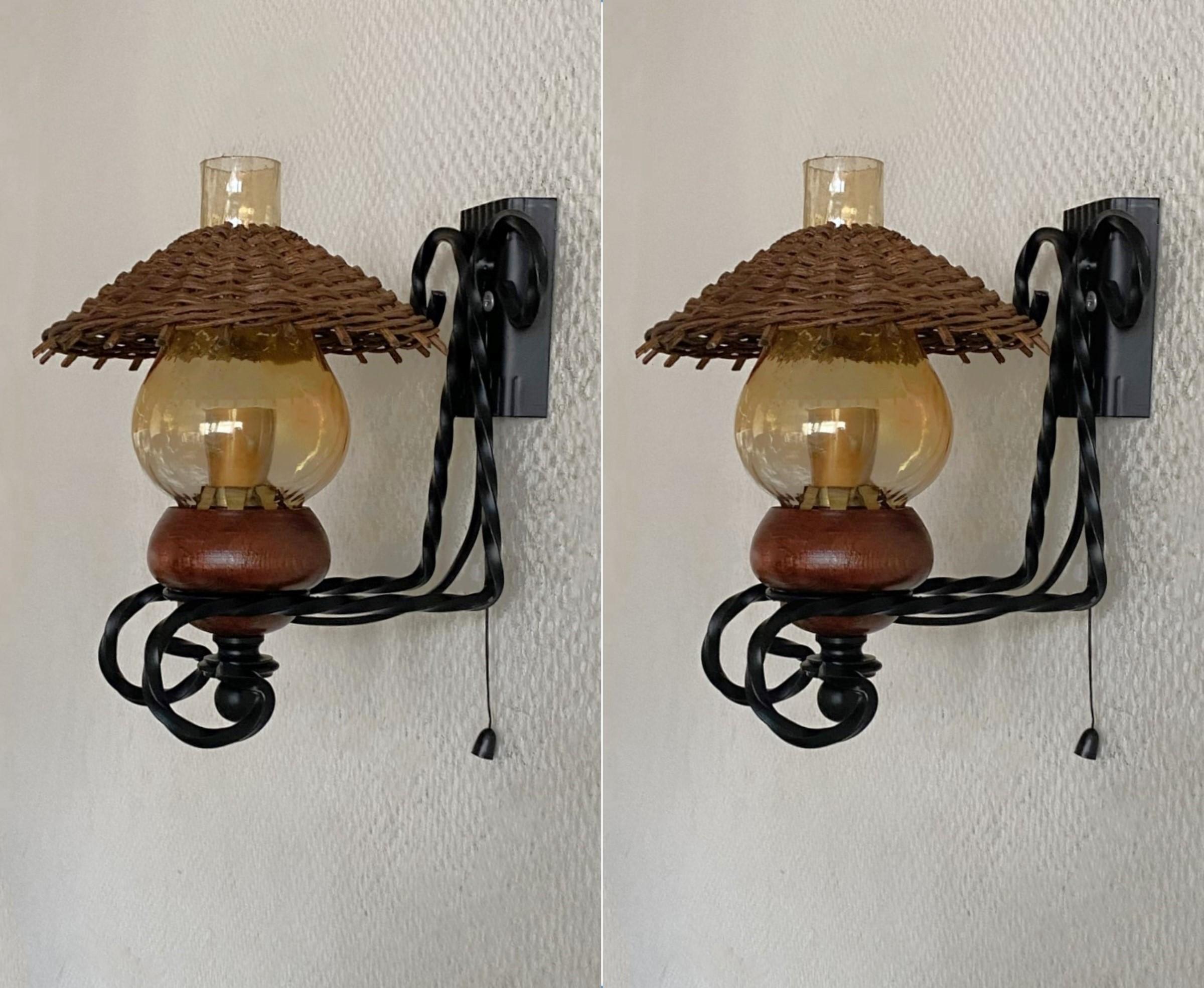 A lovely true Vintage pair of handcrafted wrought iron and wood wall lights with hurricane glass and small rattan shade, Denmark, 1960s. Each sconce takes one Edison E14 candelabra screw bulb. Both pieces in very good vintage condition, no damages,