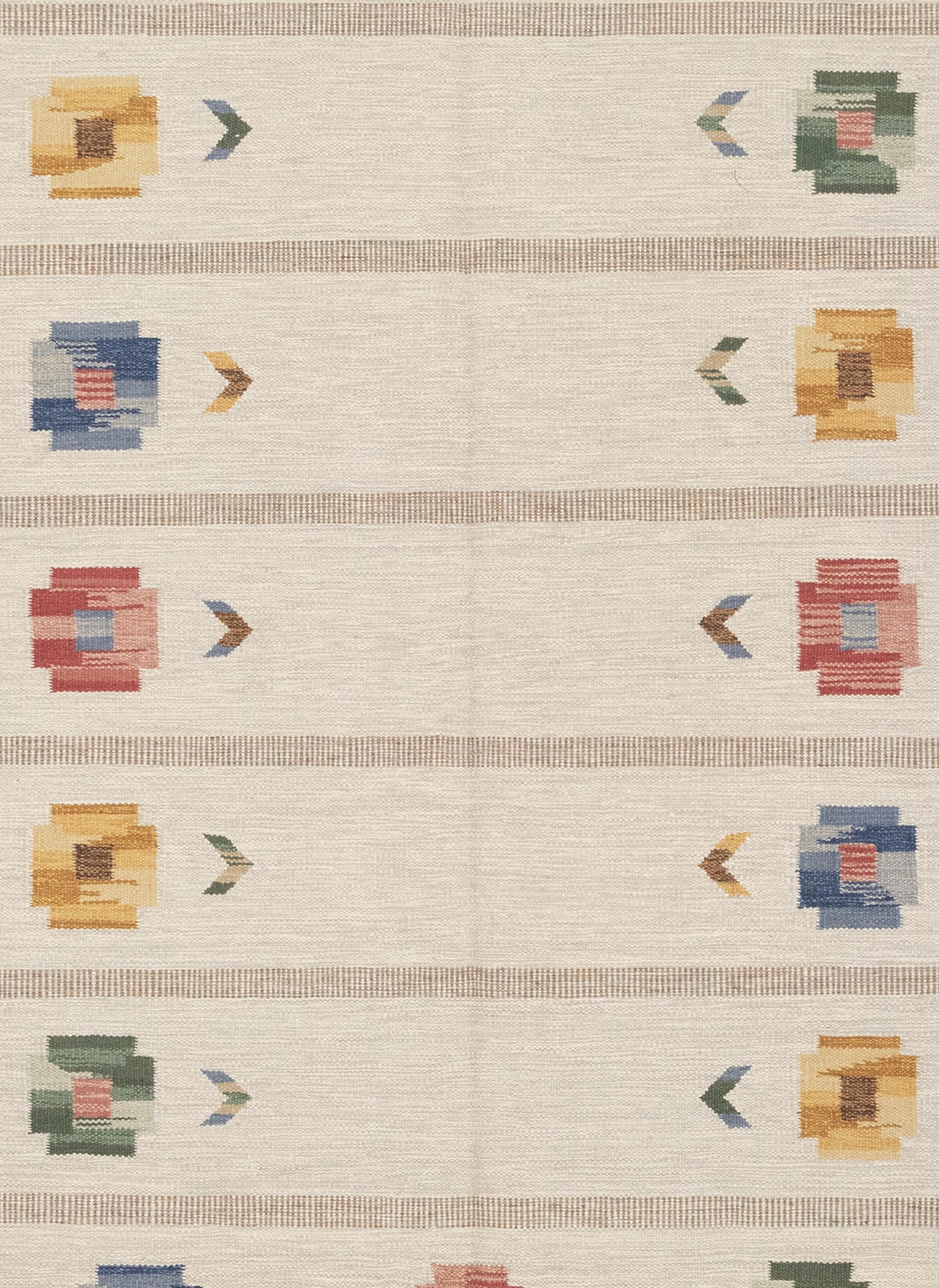 This is a vintage Scandinavian Kilim rug woven circa 1950s with quite a beautiful composition. It features an elegant display of floral motifs placed on the perimeter, like a wreath of pansies. A subdued background of gray blocks with bands of