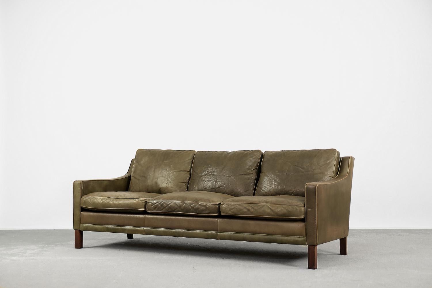 This leather three-seater President sofa was designed by Ingemar Thillmark for the Swedish manufacture OPE Möbler during the 1960s. The modernist frame and six loosely cushions were covered with natural leather in a brown-earthy color with a natural