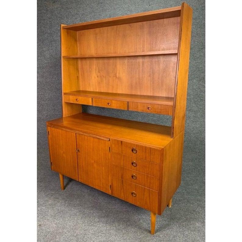 Here is beautiful vintage secretary bookcase in teak wood manufactured in Sweden in the late 1960s and recently imported to California.
This versatile piece offer book storage/display area on its top with a set of three small drawers.
The top of