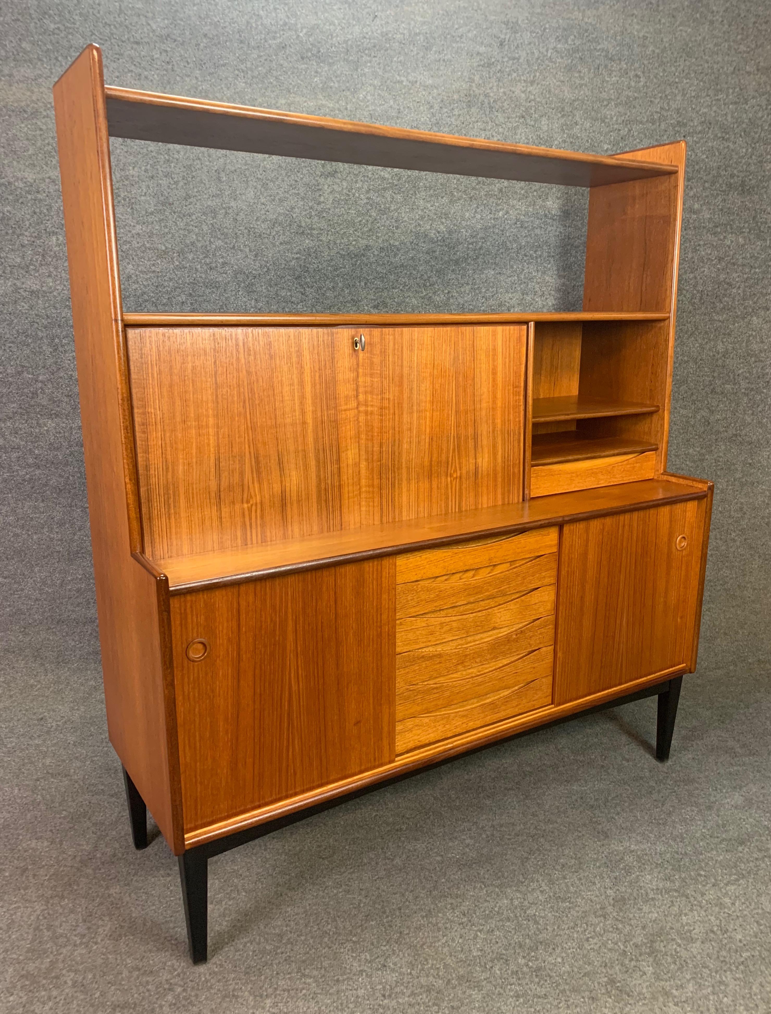 Here is a beautiful Scandinavian Modern hutch bookcase manufactured by Brantorps in Sweden in the 1960s.
This special case piece, recently imported to California before its refinishing, features a vibrant wood grain contrasting between teak and oak