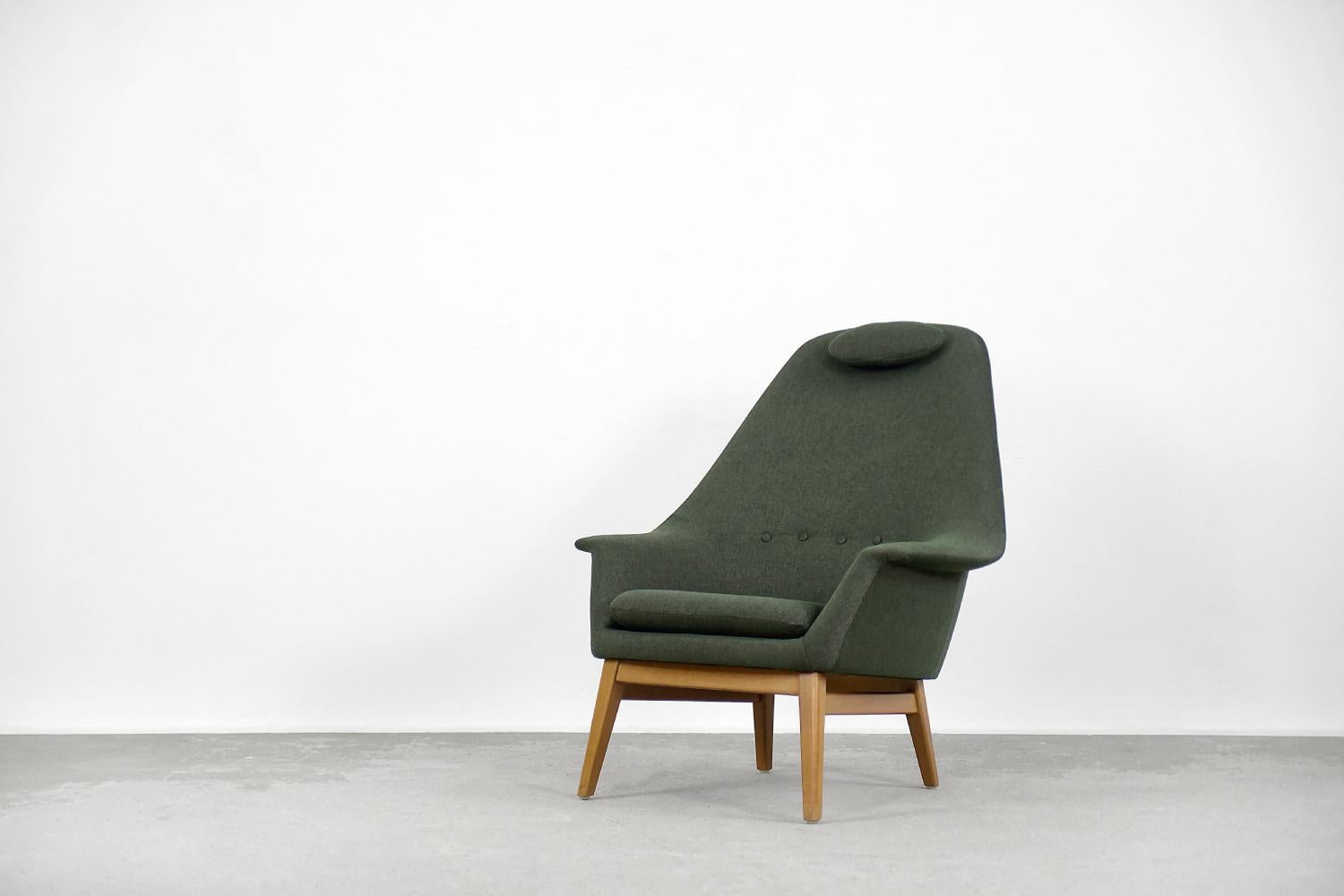 This rare form armchair was made in Scandinavia during the 1950s. The organic form of the backrest gently transforms into wide armrests resembling wings. The armchair has a small pillow under the head, which is attached with a leather strap. This