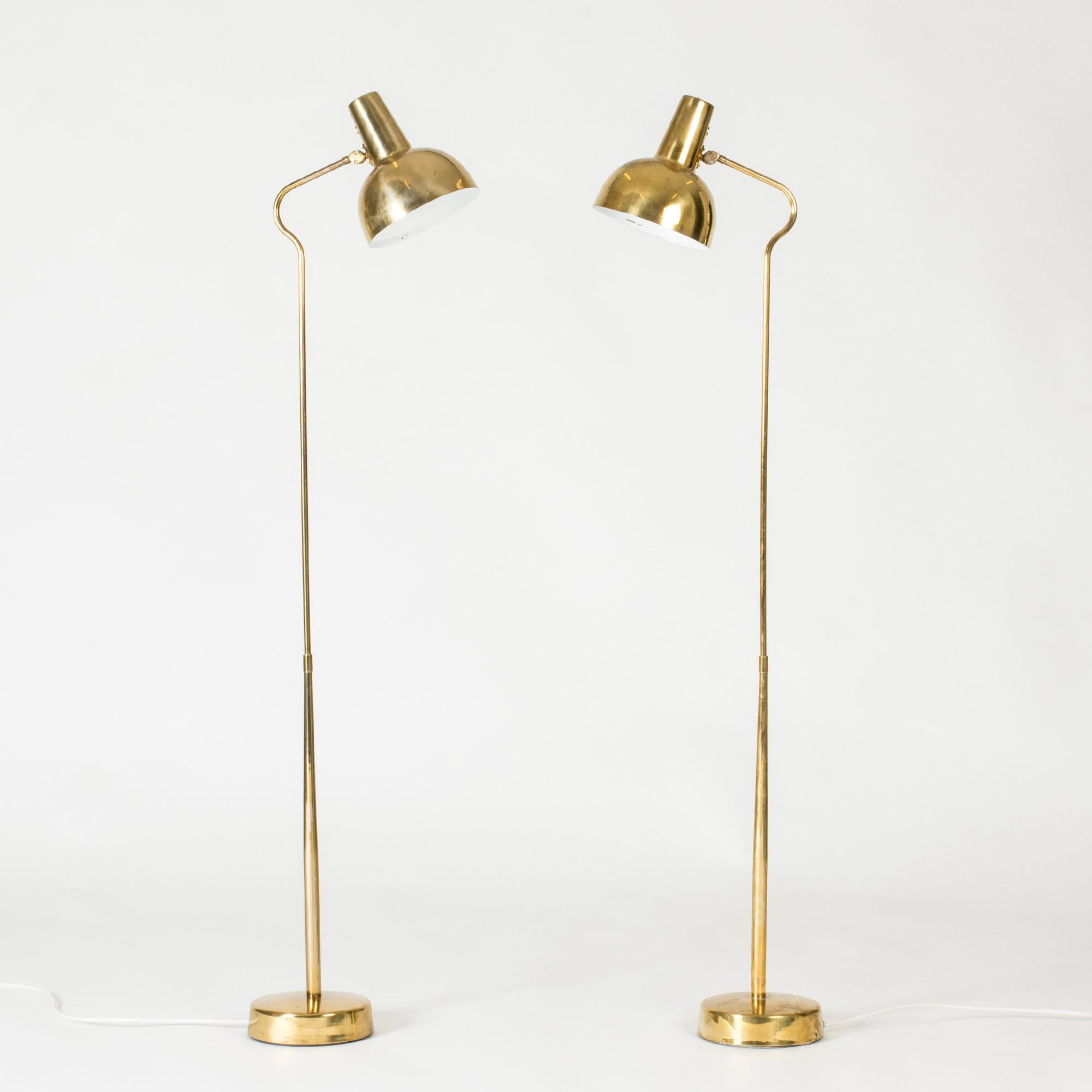 Pair of elegant brass floor lamps from ASEA in a sleek design with elegant curves. Warm glow of the brass.