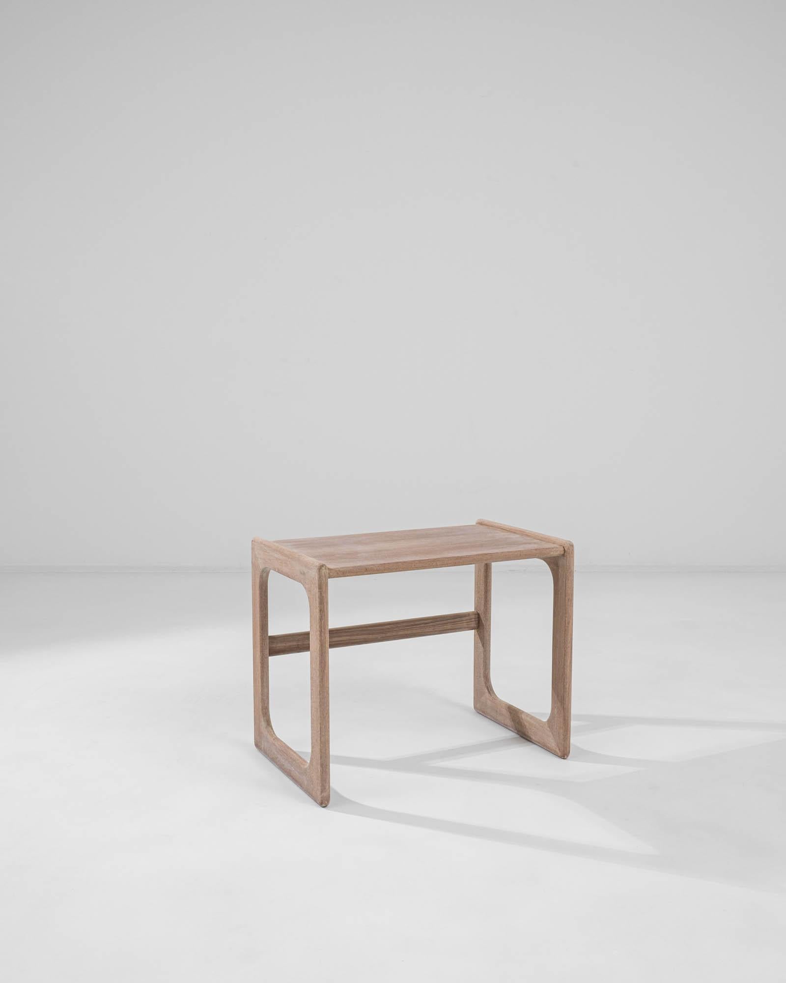 This Danish table, made circa 1970, is composed with a sharp modernist design. Elegantly minimal, the frame-like legs connect to a flat tabletop, their rectangular forms gently rounded to create a play of geometry. Simple forms are highlighted by a