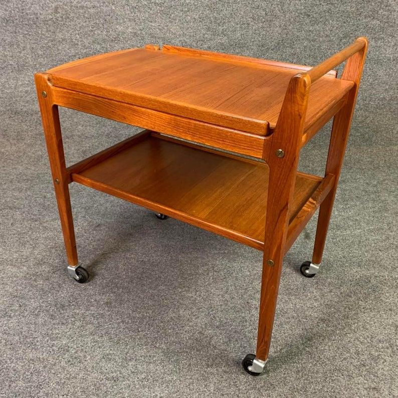 Here is a clever Scandinavian Modern teak cart designed by Erik Gustafssons and manufactured in Sweden by Britattorp Mobelfabrik in Sweden in the 1960's. It features a removable tray top with contoured corners to fit into the cart flared edge, a