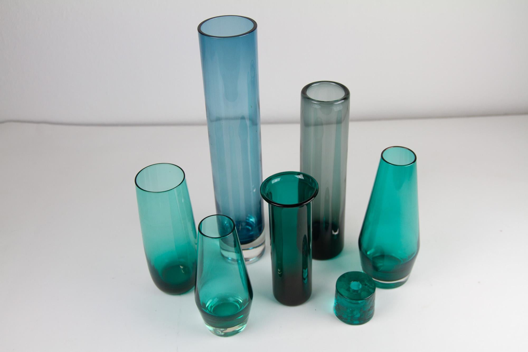 Vintage Scandinavian Modern green glass vases, 1960s. Set of 7.
Beautiful set of Scandinavian hand blown glass vases in different shades of green.
This collection consists of:

1 Tall cylindrical vase in clear and teal. Measures: Height 31.5