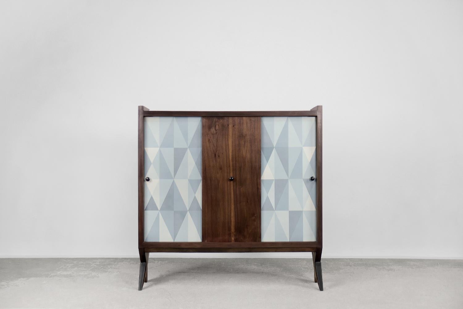 This modernist high cabinet was made in Scandinavia during the 1960s. The cabinet has been finished with high-quality walnut wood with a dark, noble color and distinctive graining. The front consists of three sliding doors. Two of them is decorated