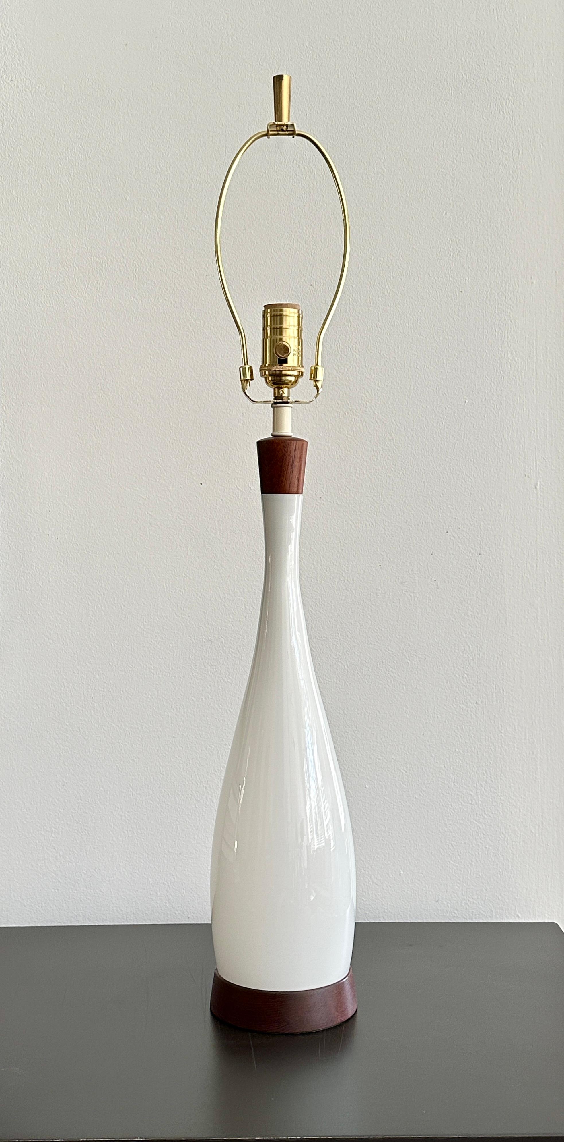 Lampe de table vintage conçue par Jacob Bing pour Kastrup au milieu des années 1960, fabriquée au Danemark. La lampe est composée de teck et de verre opalin blanc. La lampe a été totalement nettoyée à l'intérieur et à l'extérieur, la prise avec