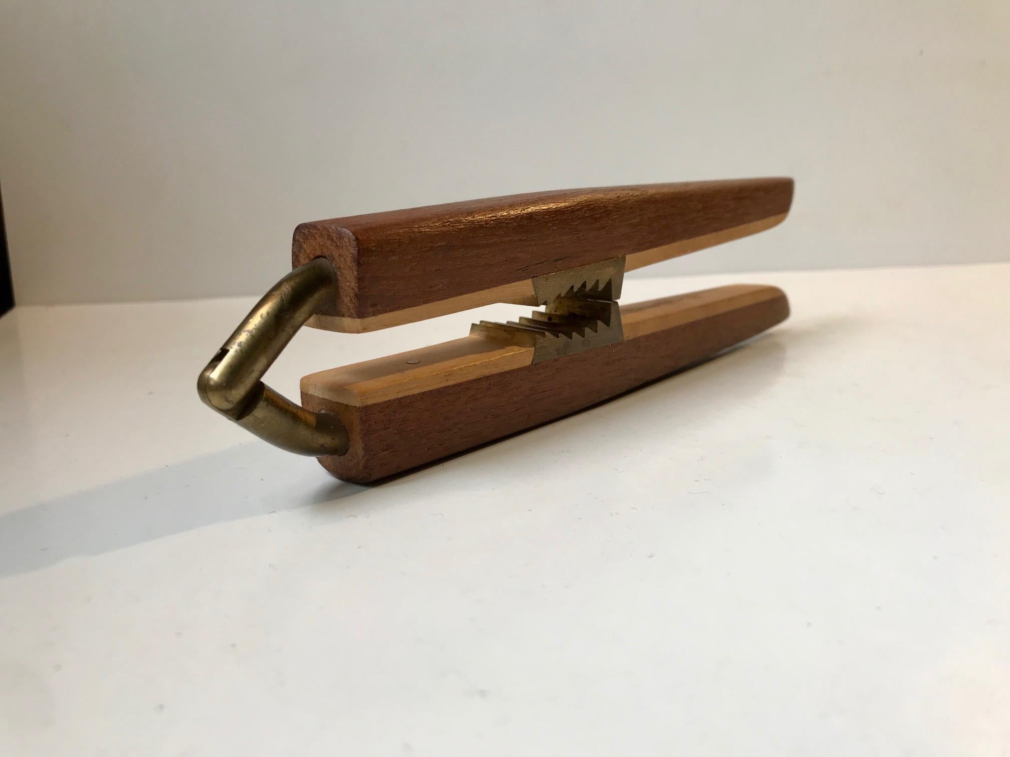 Height quality nut cracker in teak and brass. Designed for and manufactured by Hugo V. Larsen in Denmark during the 1960s in a style reminiscent of Carl Aubock and Poul Knudsen.