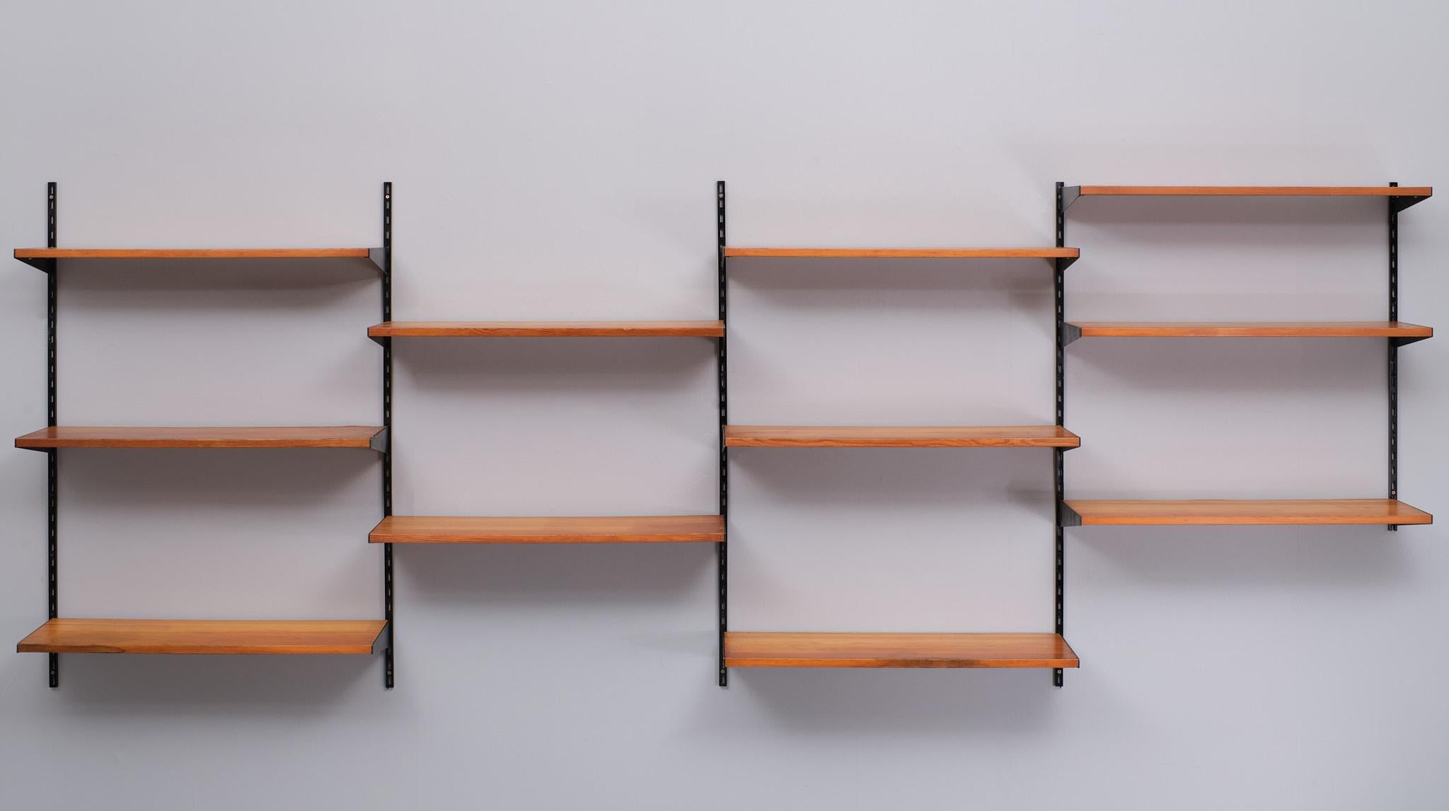 Vintage Scandinavian pine shelf by Pelly System designed in 1947, is fully modular and compatible. 11 pine shelves. Very nice Wall system . 6 Black rails 
.Marks and scratches of use.