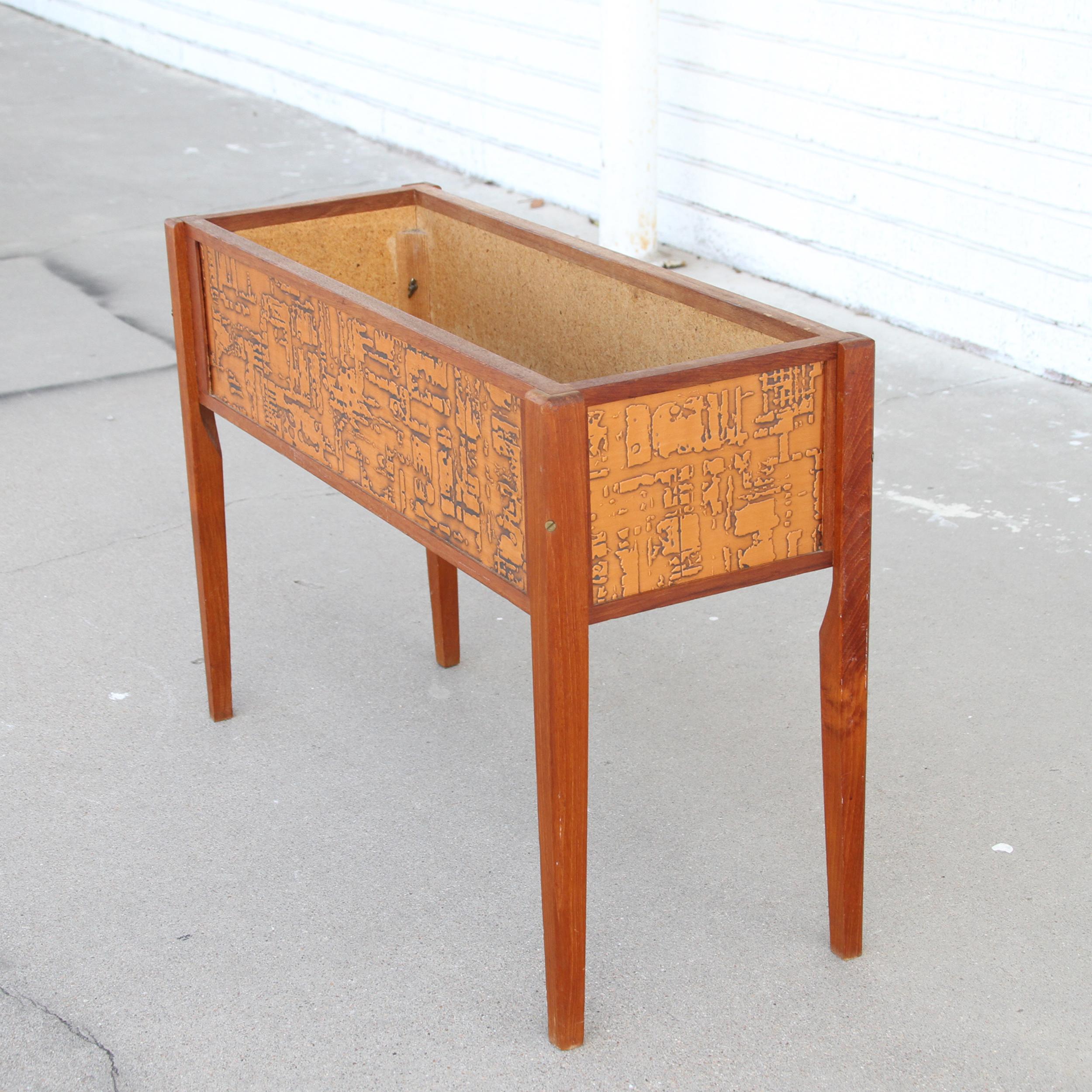 Este macetero escandinavo vintage tiene los laterales de cobre prensado y sería una hermosa pieza de acento para cualquier hogar u oficina. Sus esbeltas patas de teca y los laterales de cobre prensado son un contraste perfecto.