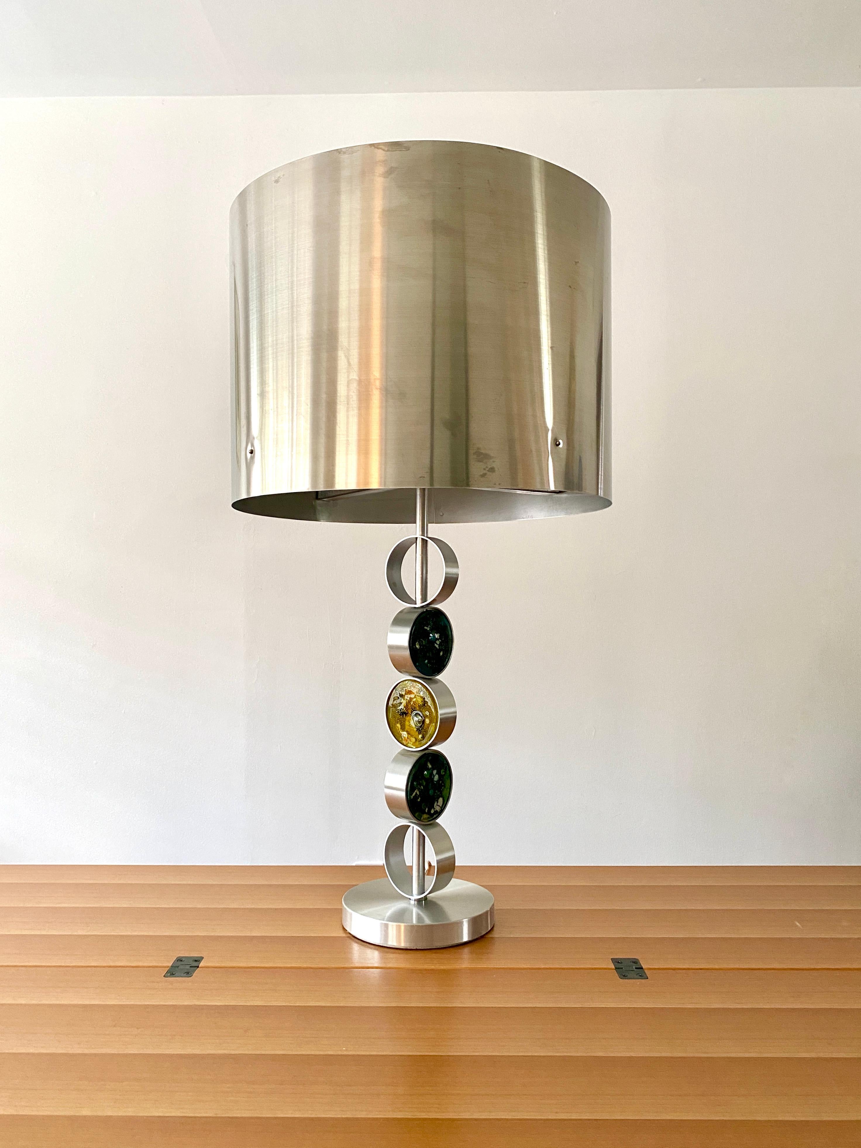 A large aluminum and steel table lamp with three art glass rondels by Finnish designer Nanny Still. The lamp was manufactured by RAAK Lighting Company in the Netherlands, designed in 1972 and is model number D2095. The lamp is in the brutalish /