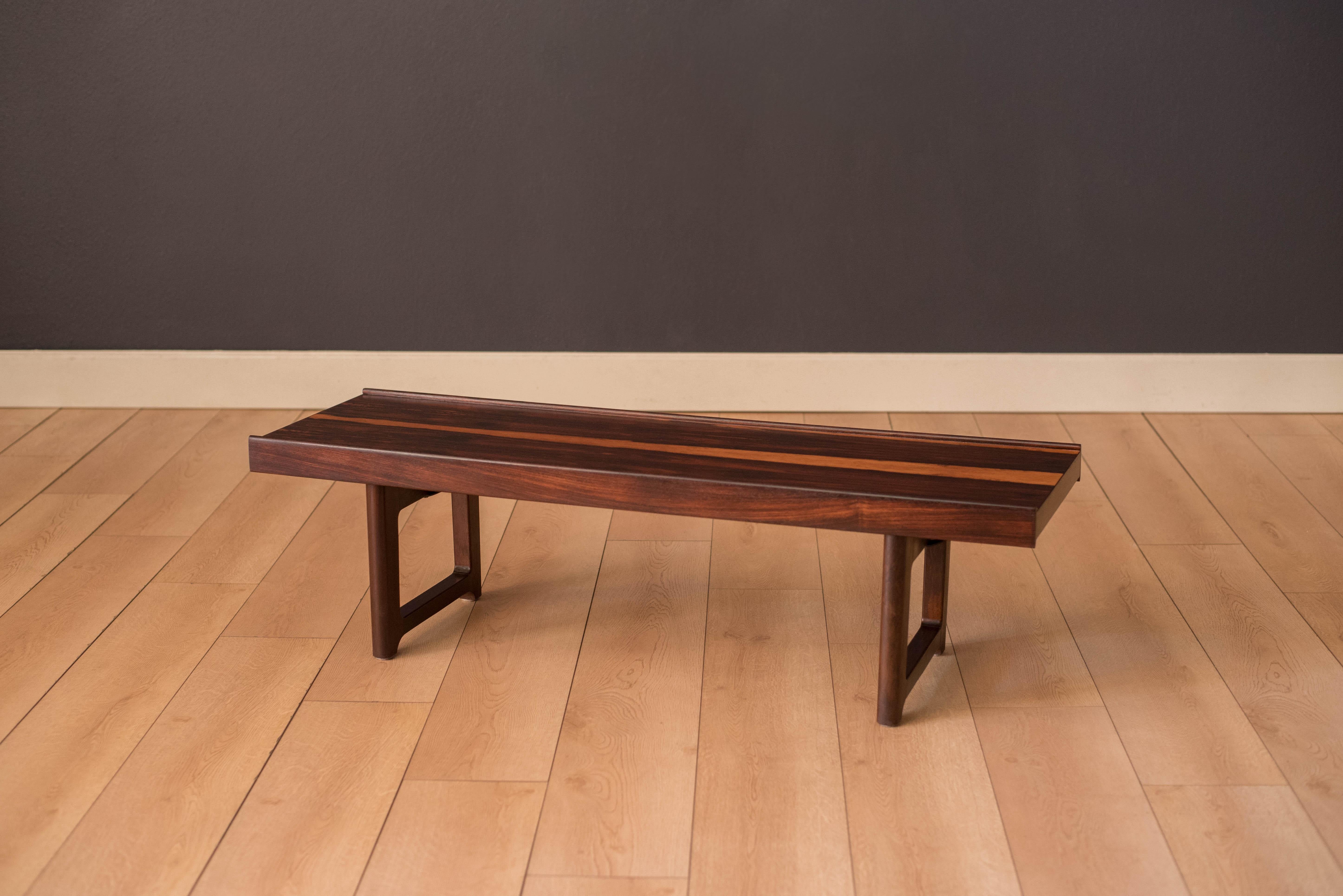 Mid-Century Modern low coffee table bench designed by Torbjørn Afdal for Bruksbo, Norway. This piece displays rich rosewood grains and sculpted edges. The perfect fit for an entryway piece or bedroom seating. 