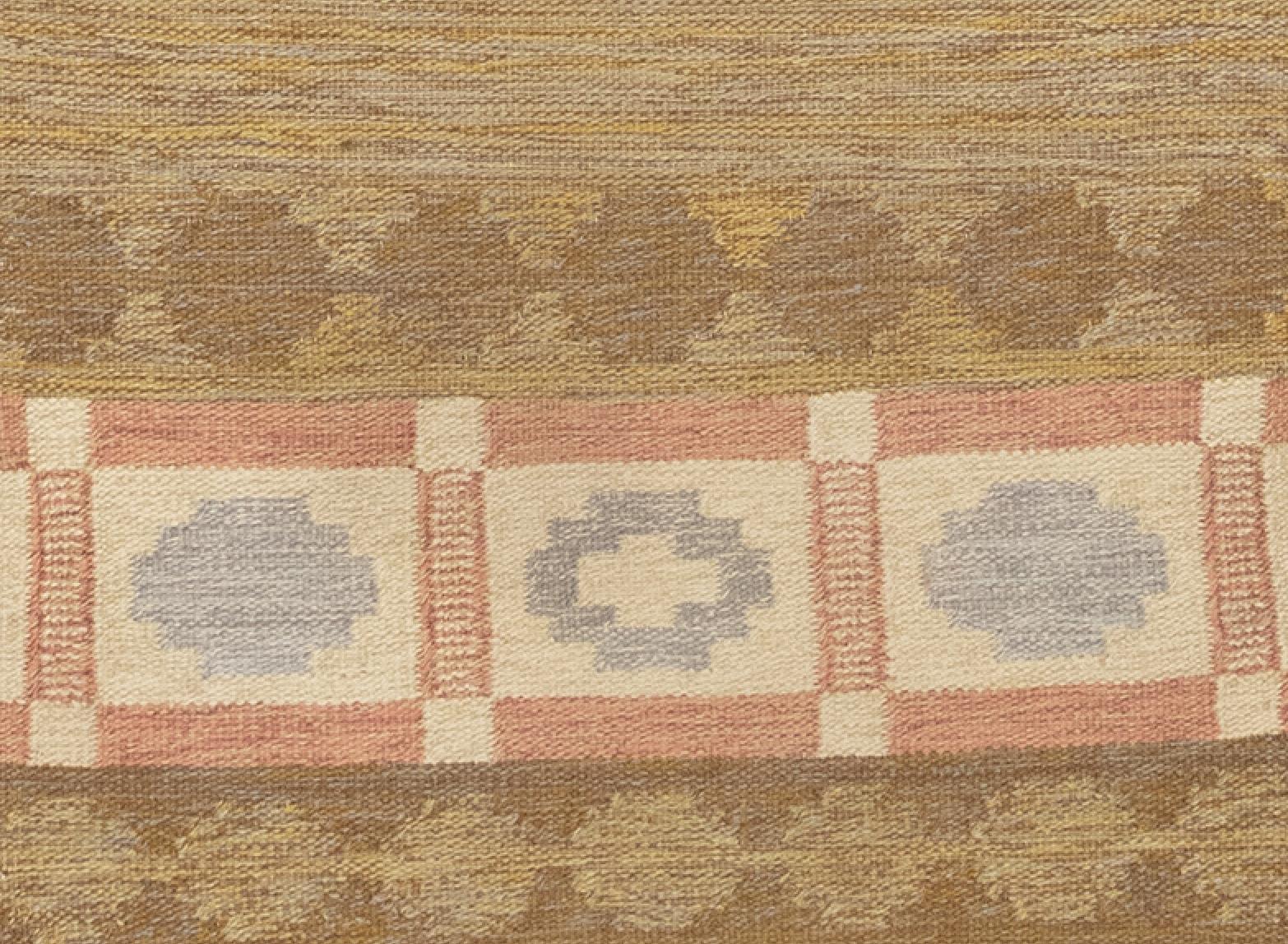 This is Scandinavian flat woven runner from circa 1950. It features a charming color palette based on pastel tones of soft colors. In the ground, the combination of brown, blue, yellow, and ivory creates a fascinating warm and cool marl effect.