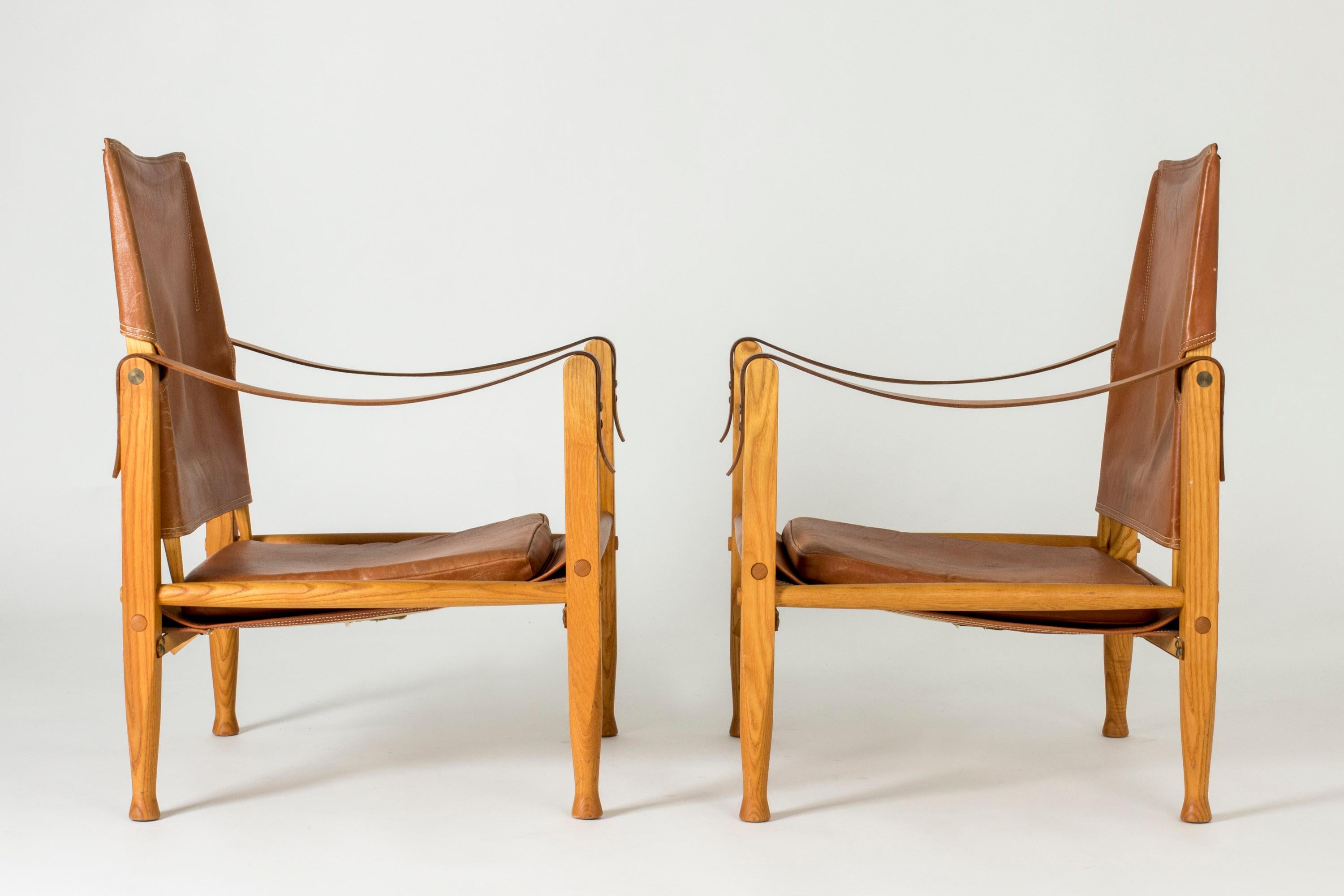 Pair of cool “Safari” lounge chairs by Kaare Klint. Oak frame with nicely tapering legs, cognac leather with very nice details.