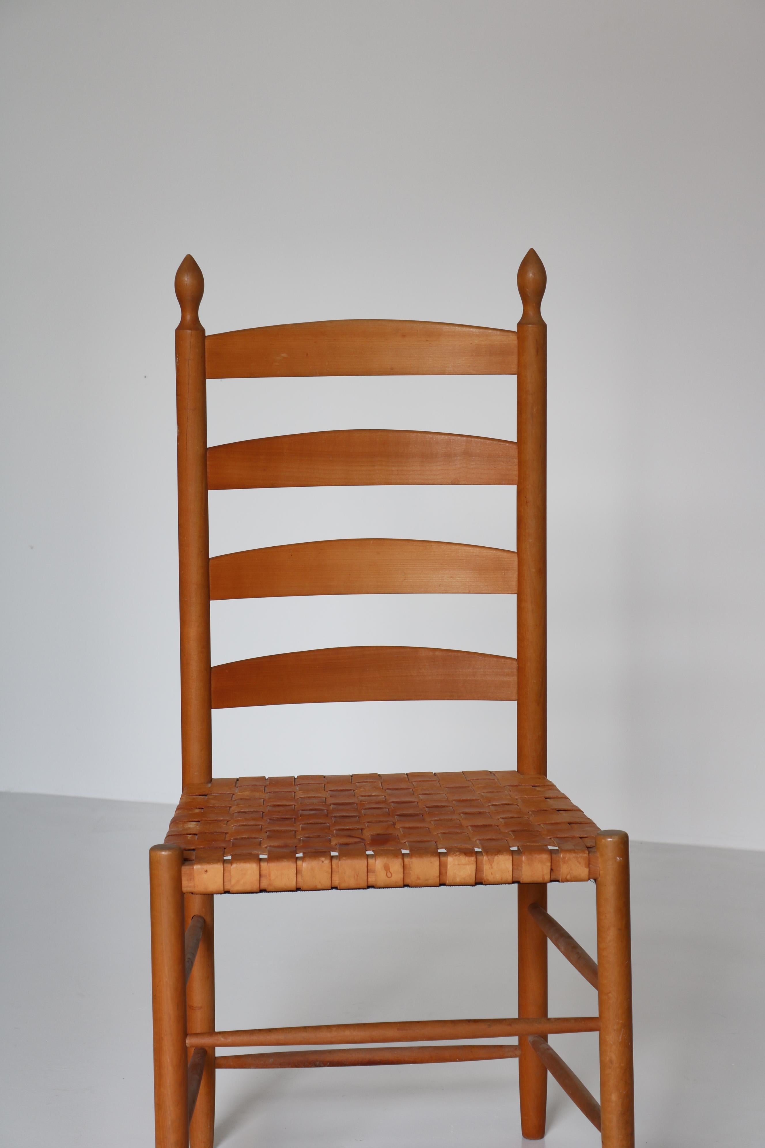 Vintage Shaker-style ladder back chair by Danish cabinetmaker in the 1960s. The chairs is made from cherrywood and the seat woven saddle leather straps with a beautiful patina. The shaker American Shaker movement has an important place in the story
