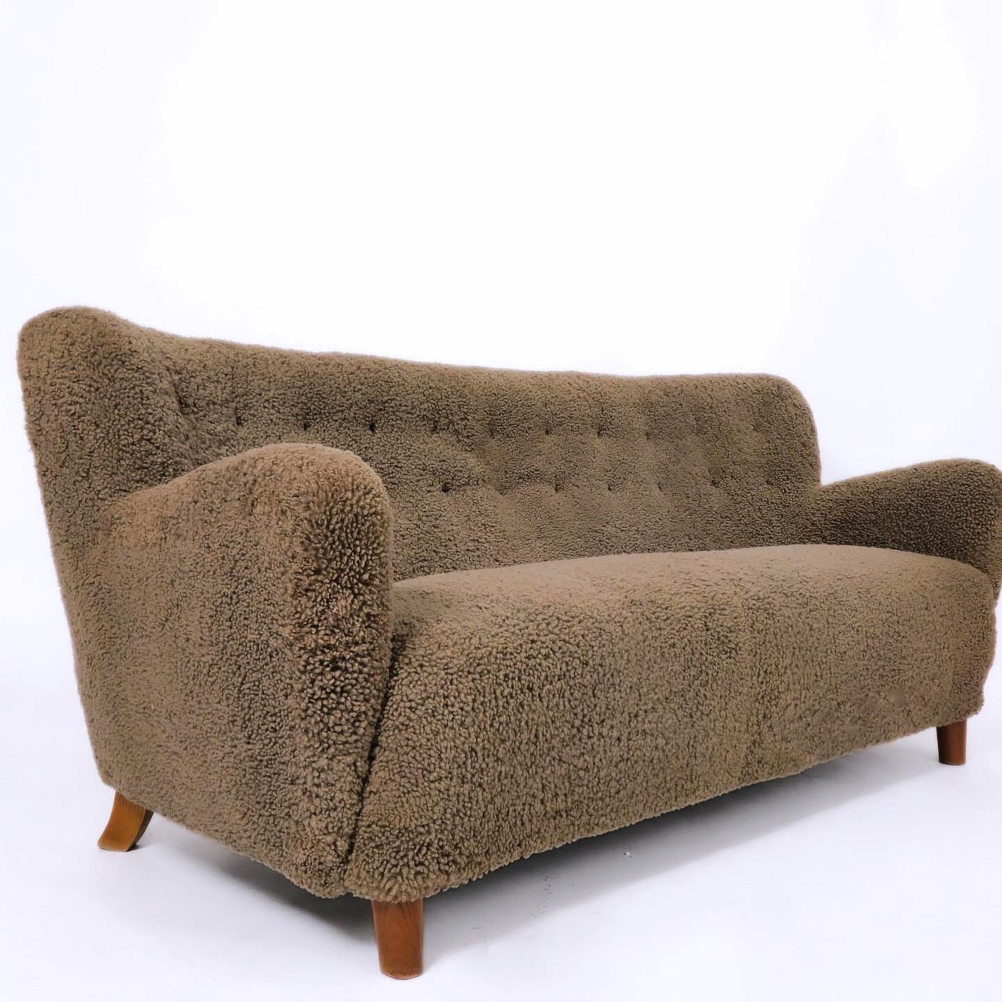 Freshly reupholstered in a mushroom-toned sheepskin. Circa 1930s-40s cabinetmaker sofa imported from Denmark. Stunning.