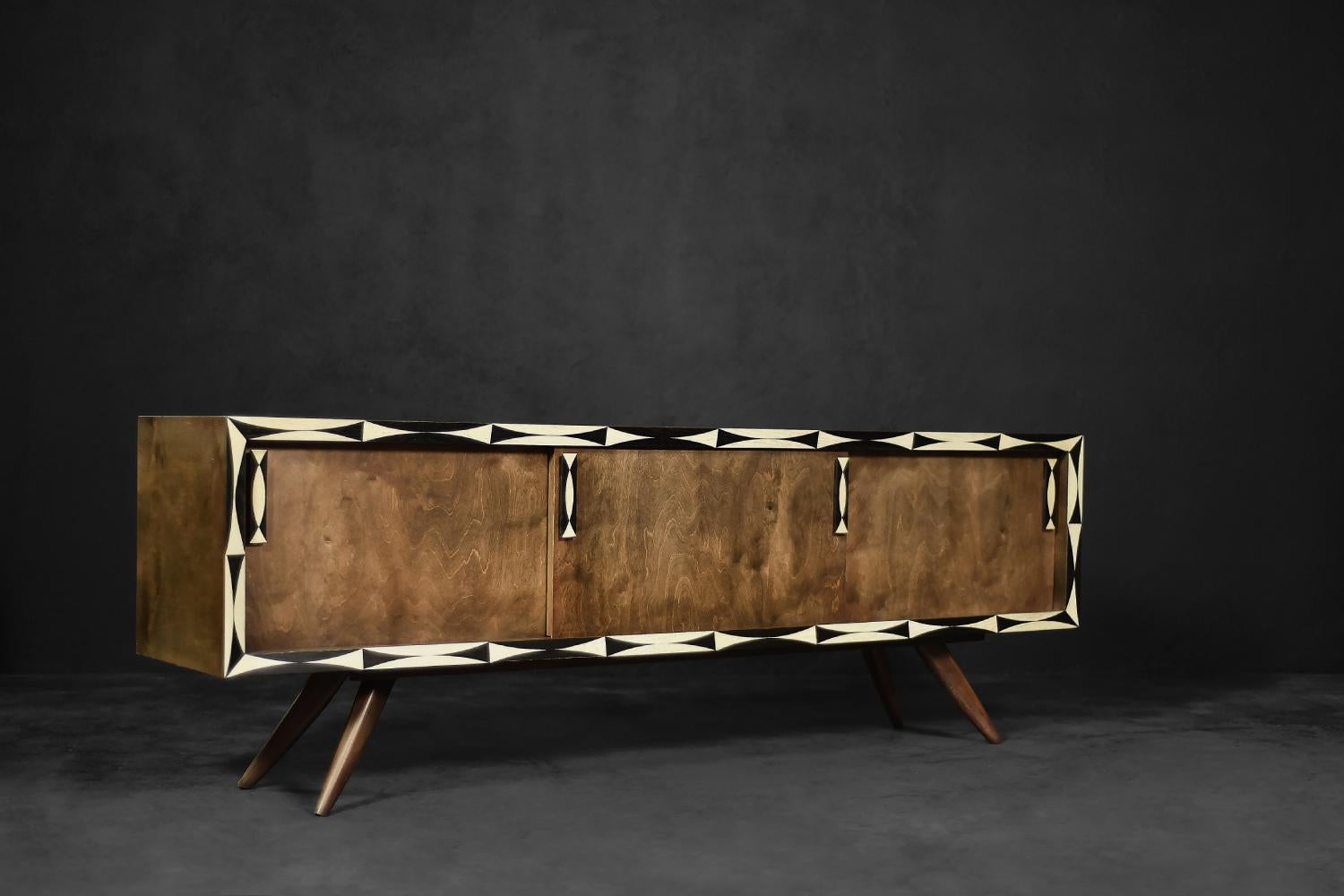 This modernist sideboard was made in Scandinavia during the 1960s. It is made of high-quality birch wood with a strong, irregular grain in a warm shade of brown. The sideboard has three sliding doors. Inside there are shelves and a capacious space.