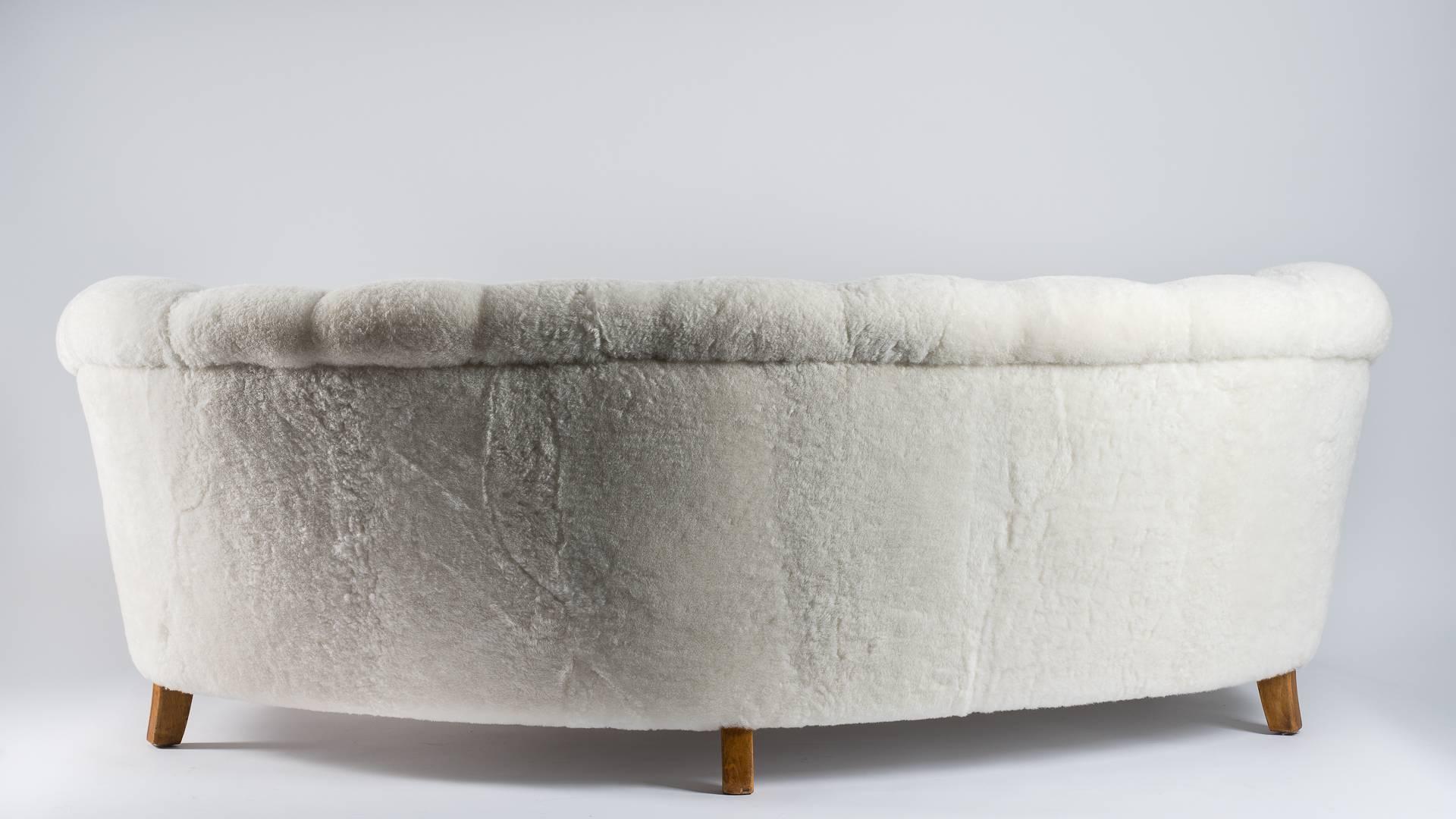 Very comfortable rounded Scandinavian vintage sofa, circa 1950
Natural white shearling upholstery.
Solid beech legs.
 