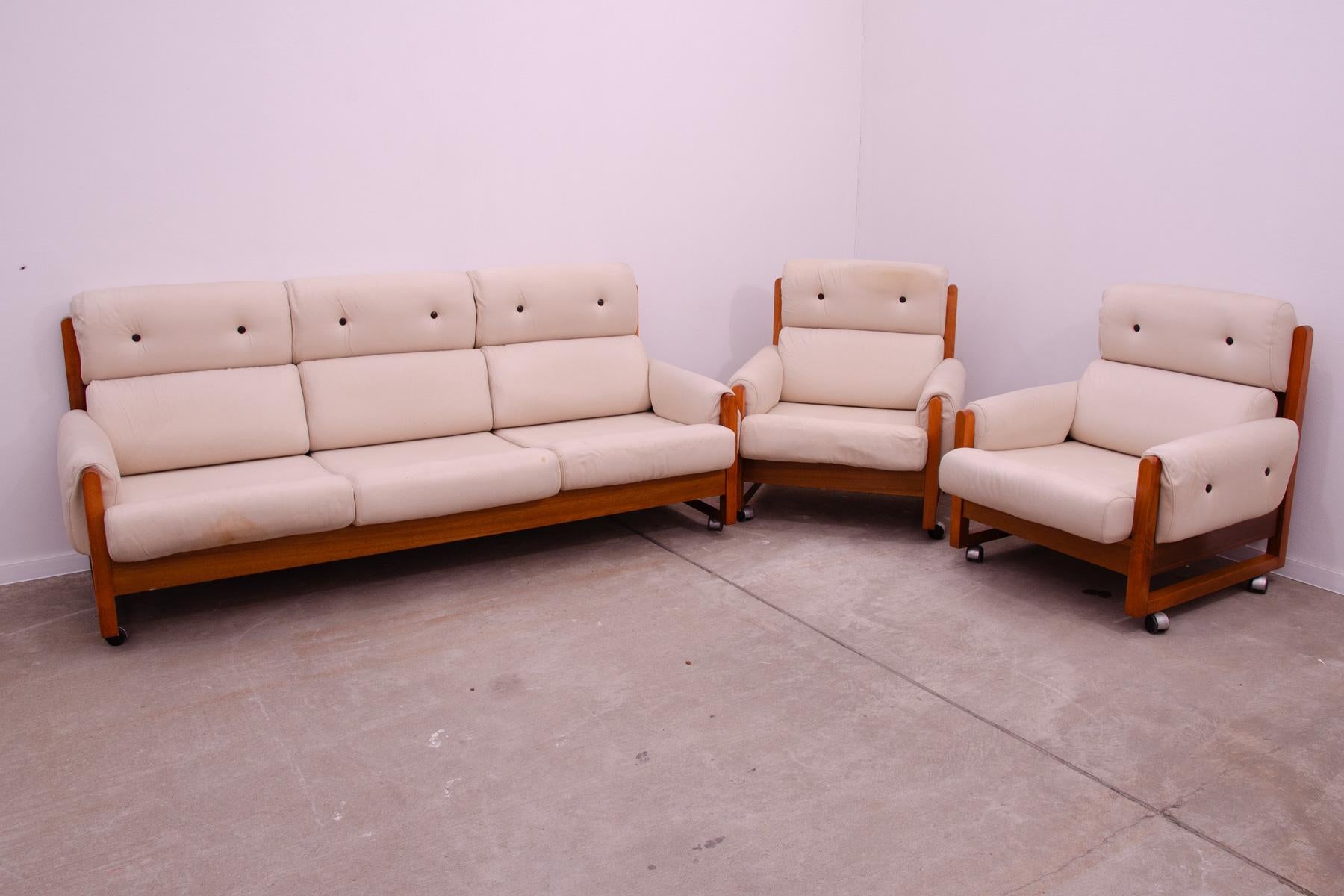 This lounge Scandinavian style living room set was made in the 1970´s in the former Czechoslovakia. Consists of one sofa and two armchairs. The set is upholstered with fabric. The structure is made of beech wood and the furniture stands on metal
