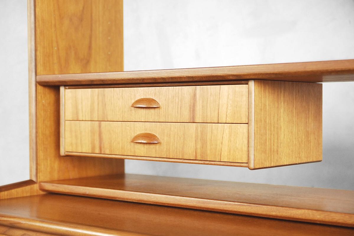 This Mid-Century Modern secretaire was manufactured in Sweden during the 1960s. It has been finished in teak. This unit consists of one piece, the parts could not be separate. The sideboard has a sliding door, four drawers and pullout desk tray (116