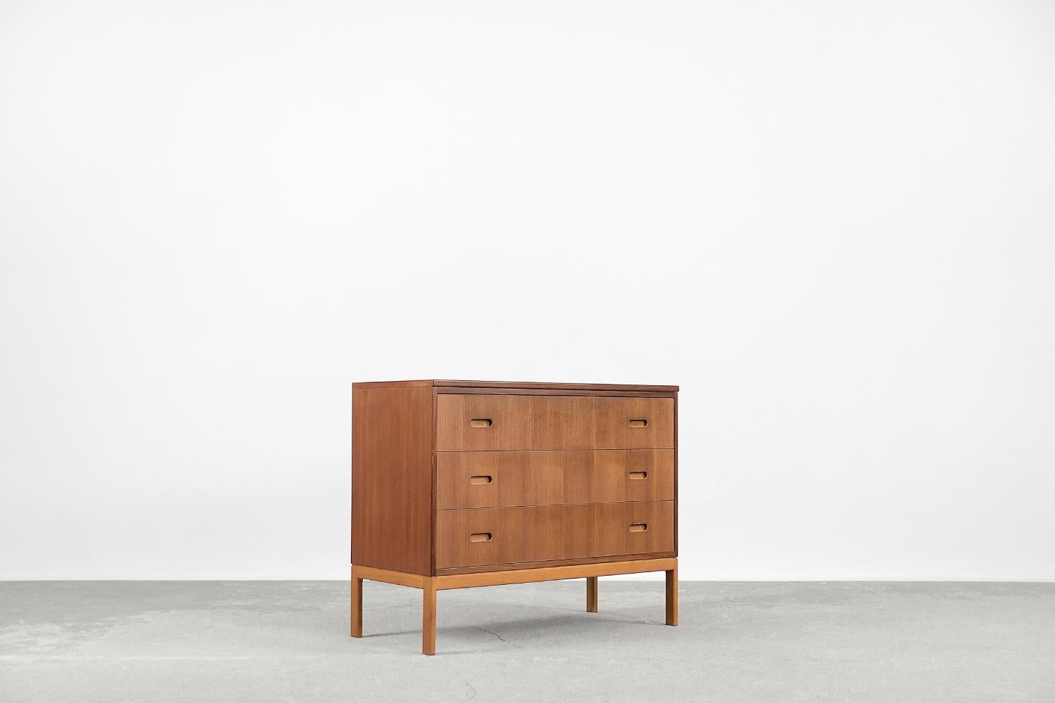 This modernist chest of drawers was produced in Sweden during the 1960s. It is finished with teak wood with regular graining and a warm, honey color. The cabinet has three spacious drawers. This piece is mounted on a strong solid wood base. It is a