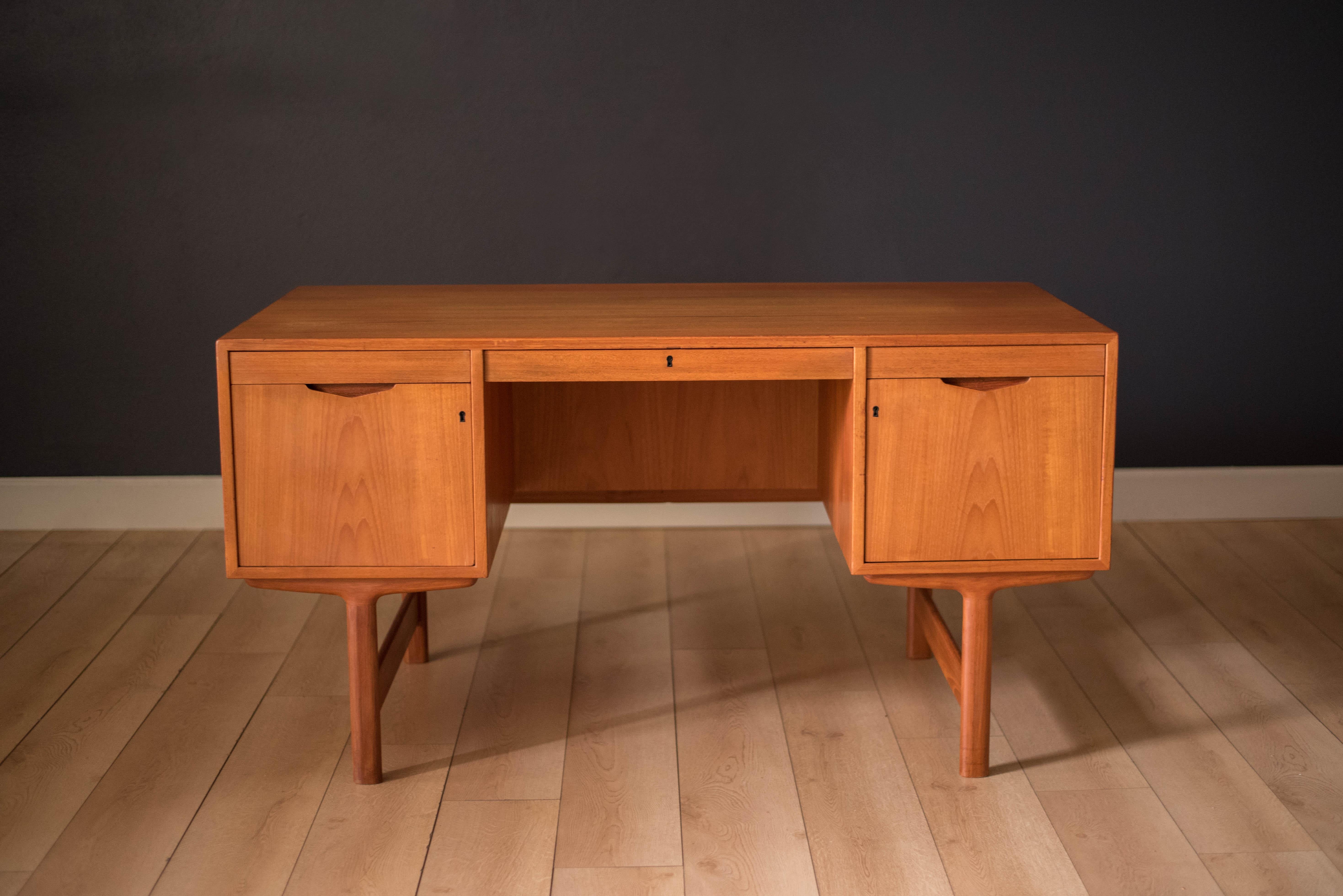Mid Century teak desk by AASE Dreieri Ganddal for Aase Mobler, Norway. Features a pull-out writing surface and three dovetailed drawers that includes one locking filing cabinet. Also, equipped with an additional open storage space with pull-out tray