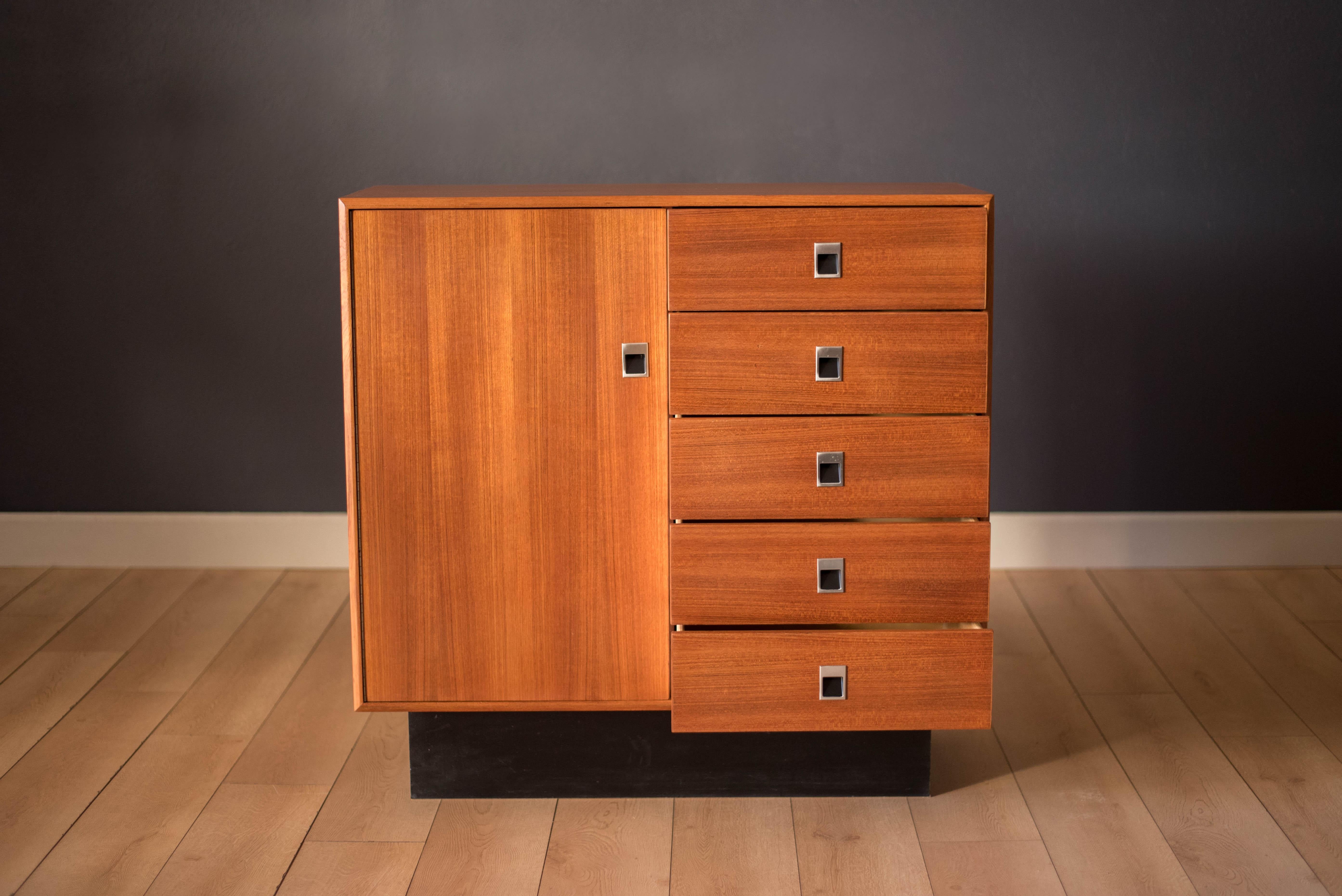Mid-Century Modern gentleman's dresser in teak, circa 1970s. This piece includes five spacious drawers and an open storage cabinet lined in mahogany including two adjustable shelves. Modernist style hardware is made of polished aluminum and the