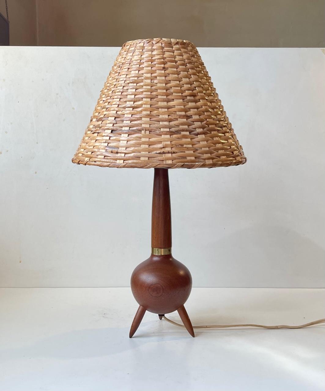 Shaped as a Satellite or Lunar landing vehicle this unusual tripod table light made from solid teak, brass has a beautiful handmade wicker shade. Made/designed anonymously in Scandinavia during the 1960s. Stylistically it corresponds with similar