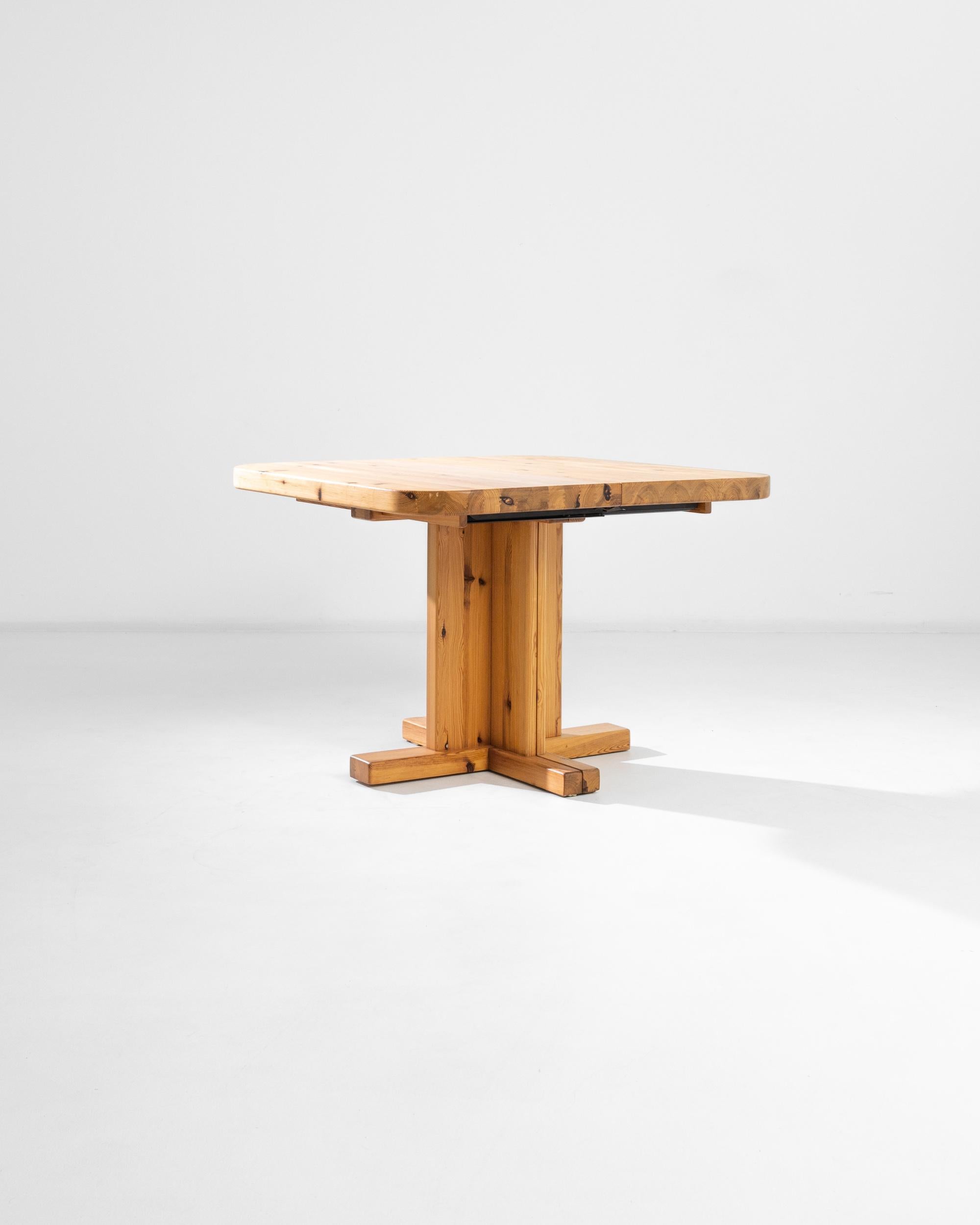 A wooden table from Scandinavia, produced during the 20th century. A quintessentially 20th century table from the land that took Mid Century Modernism to its greatest heights. A small square table made of a spirited, warm wood, standing on a single