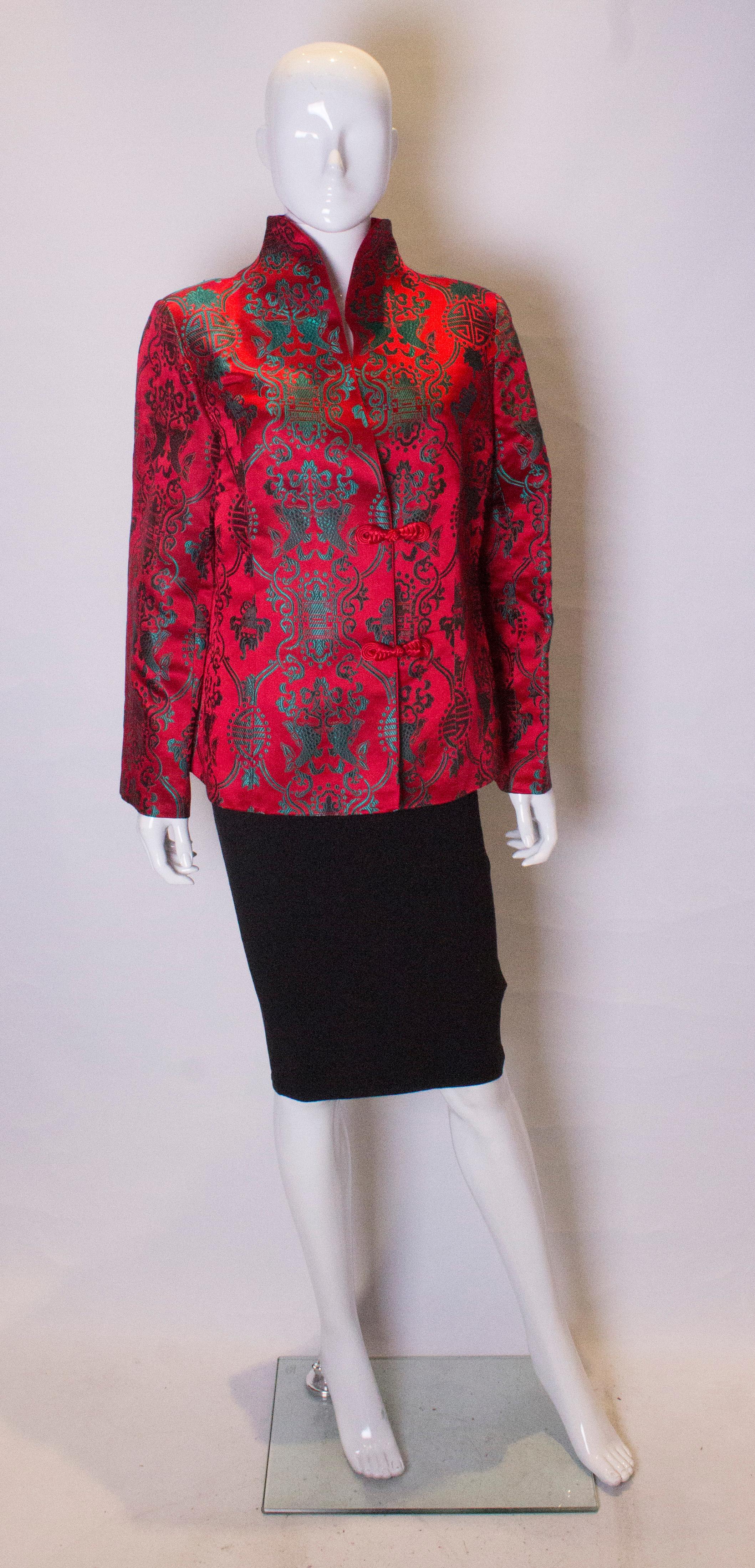 A chic and headturning Chinese jacket. The jacket is in a vibrant scarlet colour with turquoise print. It has a stand up collar and fastens with two toggles.