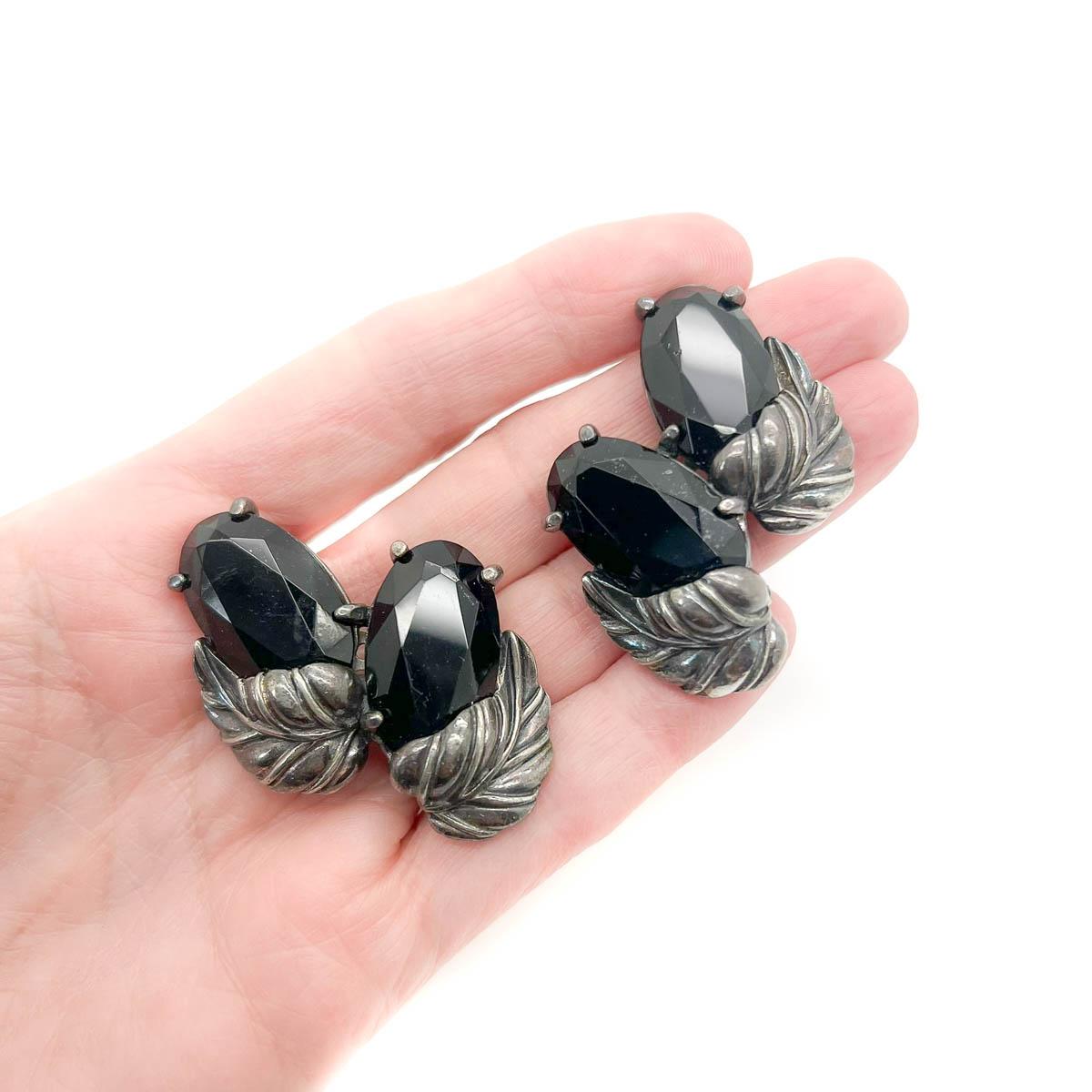 A sublime pair of Vintage Schiaparelli Fruit Earrings from the 1960s. Large faceted black crystals sit atop a leafy foliage. Join the reignited Schiaparelli following with a gorgeous vintage treasure from this extraordinary couture House.
From her