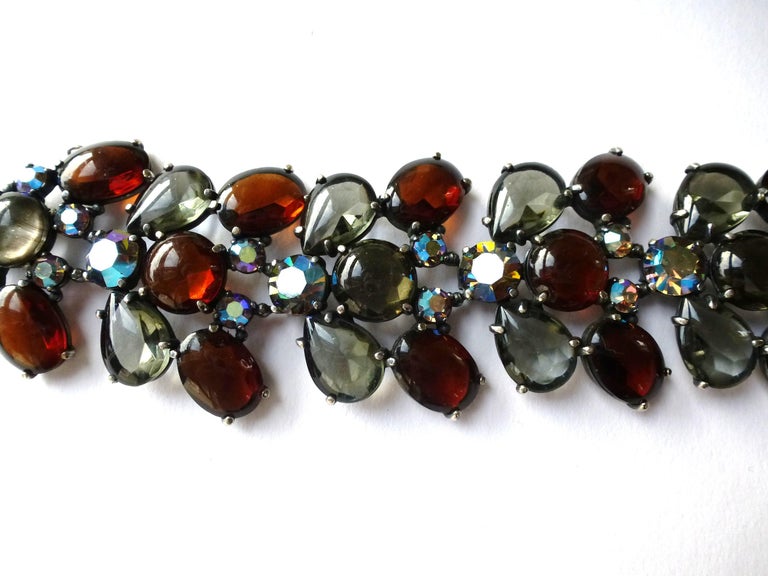 A multi crystal 5 link bracelet in brown and gray unfold rhinestones and in the middle is made of iridescent cut crystal. This relatively large and bold Schiaparelli bracelet displays a colorful crystal link pattern that forms a straight but