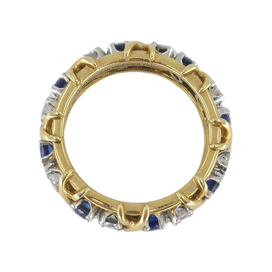 Designed by Jean Schlumberger for Tiffany & Co., this vintage band from the 1990s pairs timeless materials with a signature design. The ring features alternating round-cut blue sapphires and white diamonds, each set in platinum prongs and wrapped in