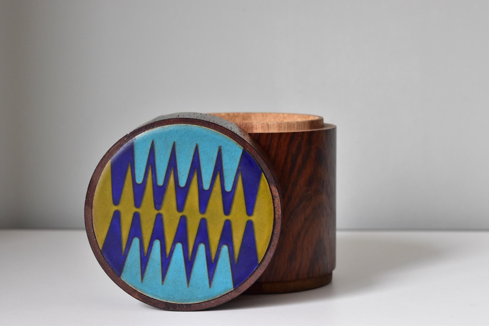 Preciosa caja Scholz & Lammel de los años 60 de madera con tapa esmaltada. Podrías utilizarlo para cigarrillos, pequeñas cosas como joyas o pequeños accesorios. 
Precio de una caja.
 