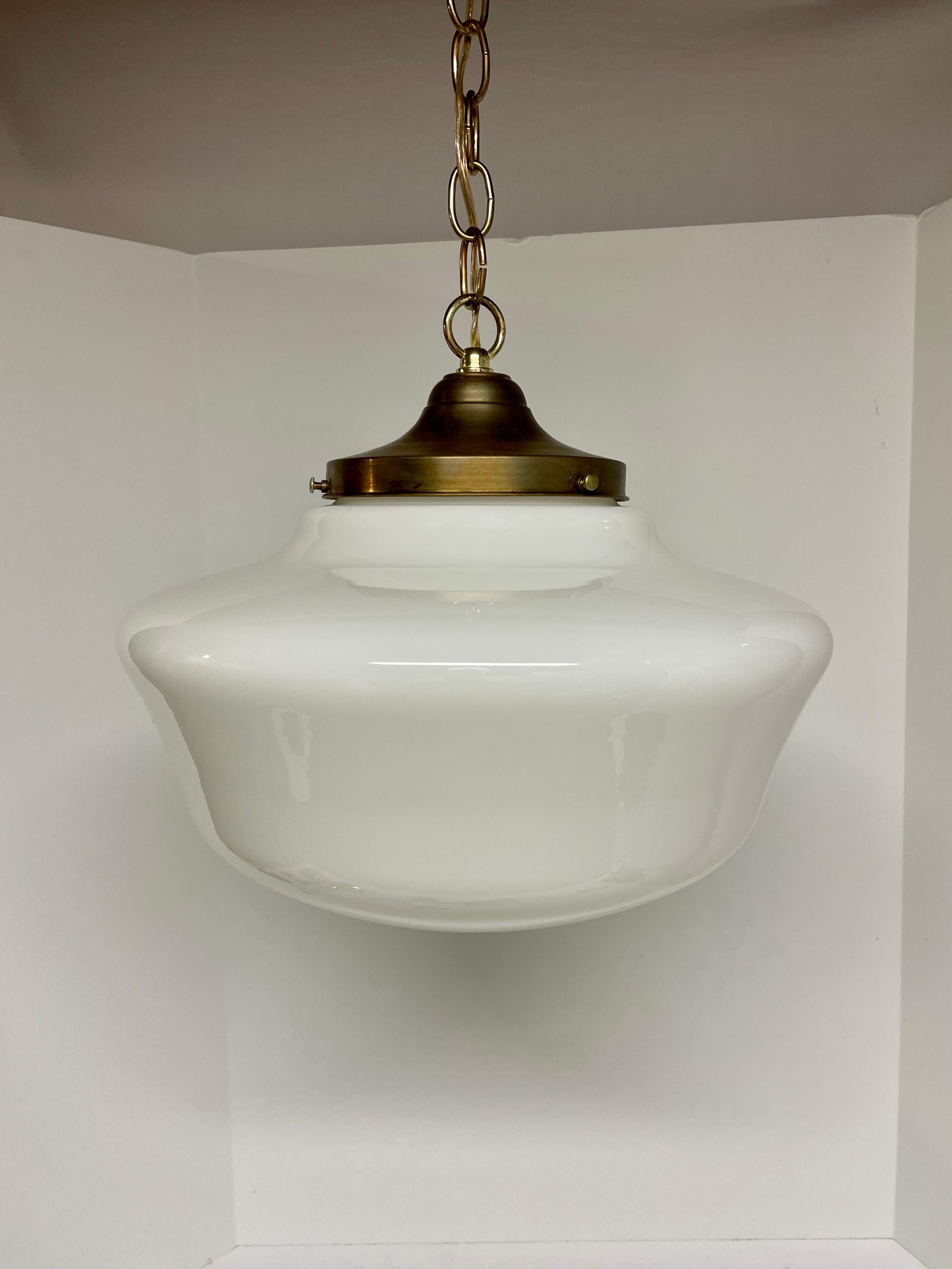 Opaline Glass Schoolhouse Light, a timeless and classic lighting fixture inspired by the iconic design of vintage schoolhouse lighting. This light features a simple and clean silhouette with a rounded glass shade that provides a warm and inviting