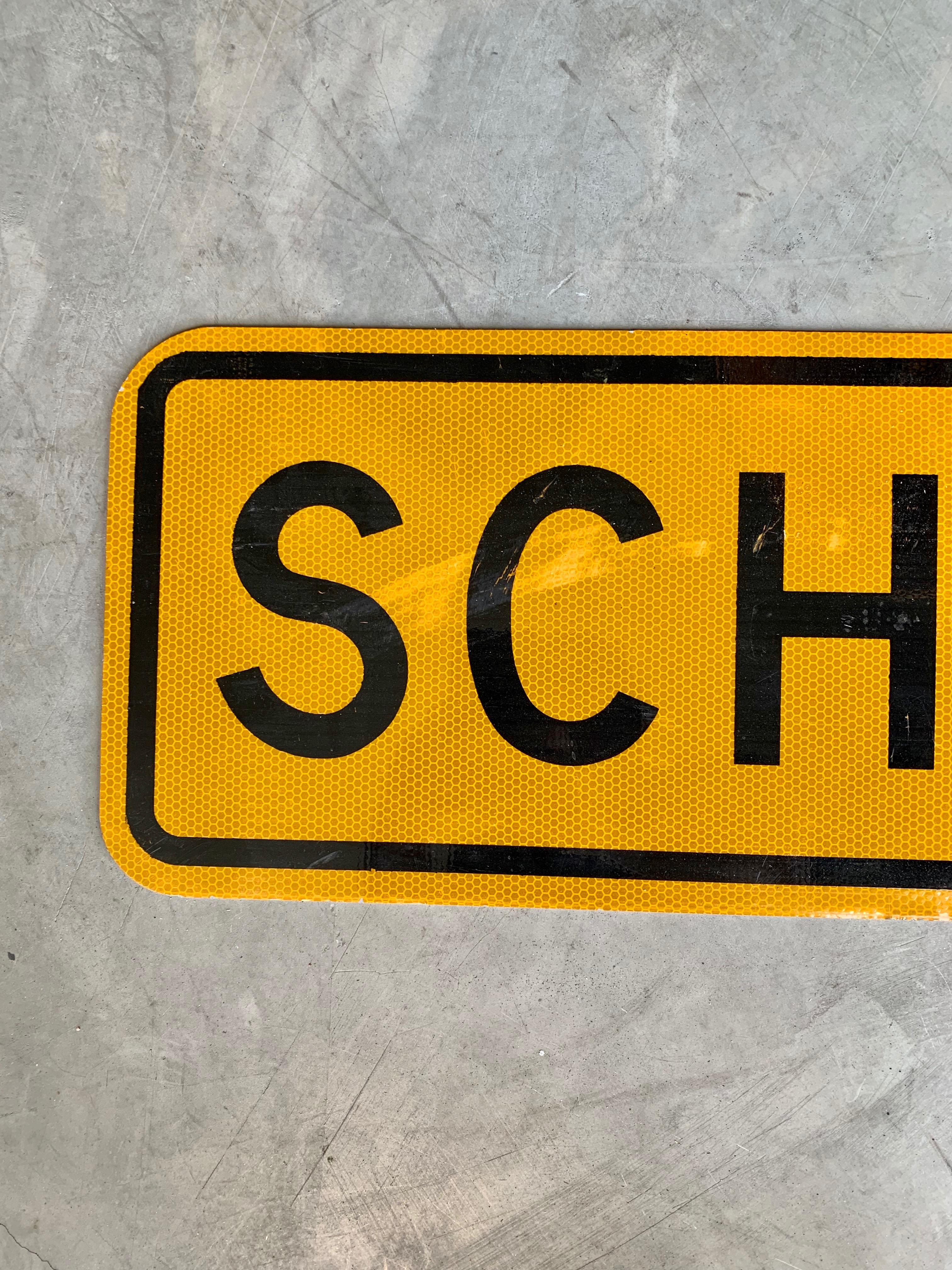 Vintage 'SCHOOL' street sign with yellow background and black lettering. Good vintage condition.
