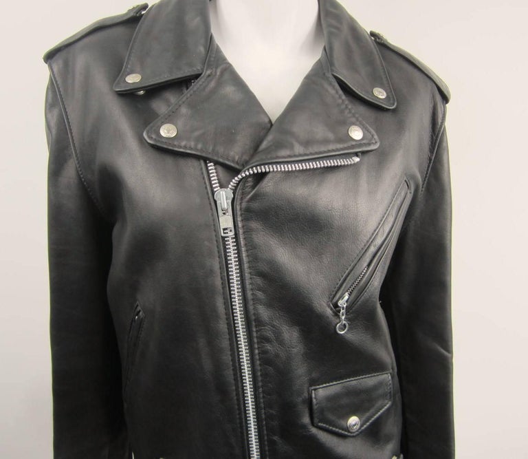 Leather moto jacket. Purchased stored away and never worn! Black Leather, 4 front pockets, cuff zips. Leather lace up sides and shoulder epaulets. Measures Up to 42 in Bust - Up to 40 in Waist. Long 47in Will Fit a Size 10-12 woman. Please check our