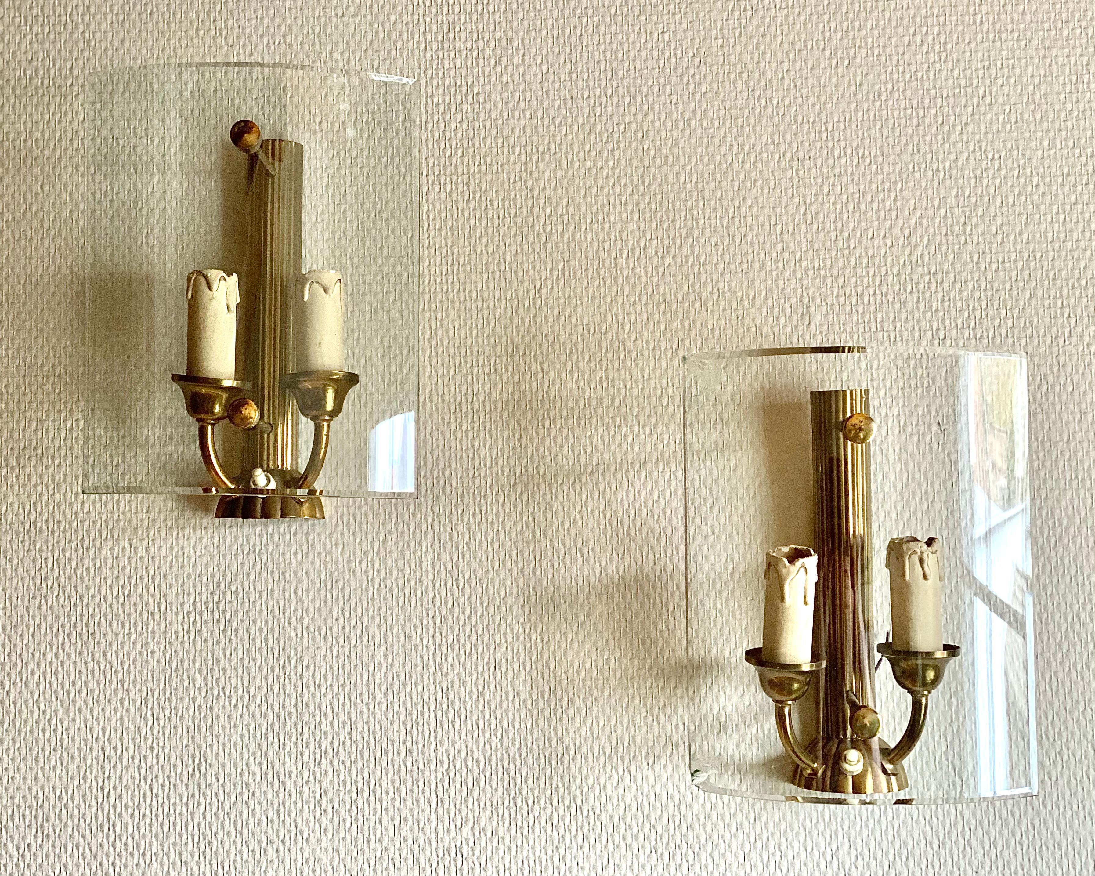 Ces élégantes appliques néoclassiques aux influences Art déco proviennent de France, vers les années 1970.

Fabriquées en laiton patiné, elles sont dotées d'un abat-jour en verre joliment incurvé qui diffuse la lumière en douceur. Ils ajoutent une