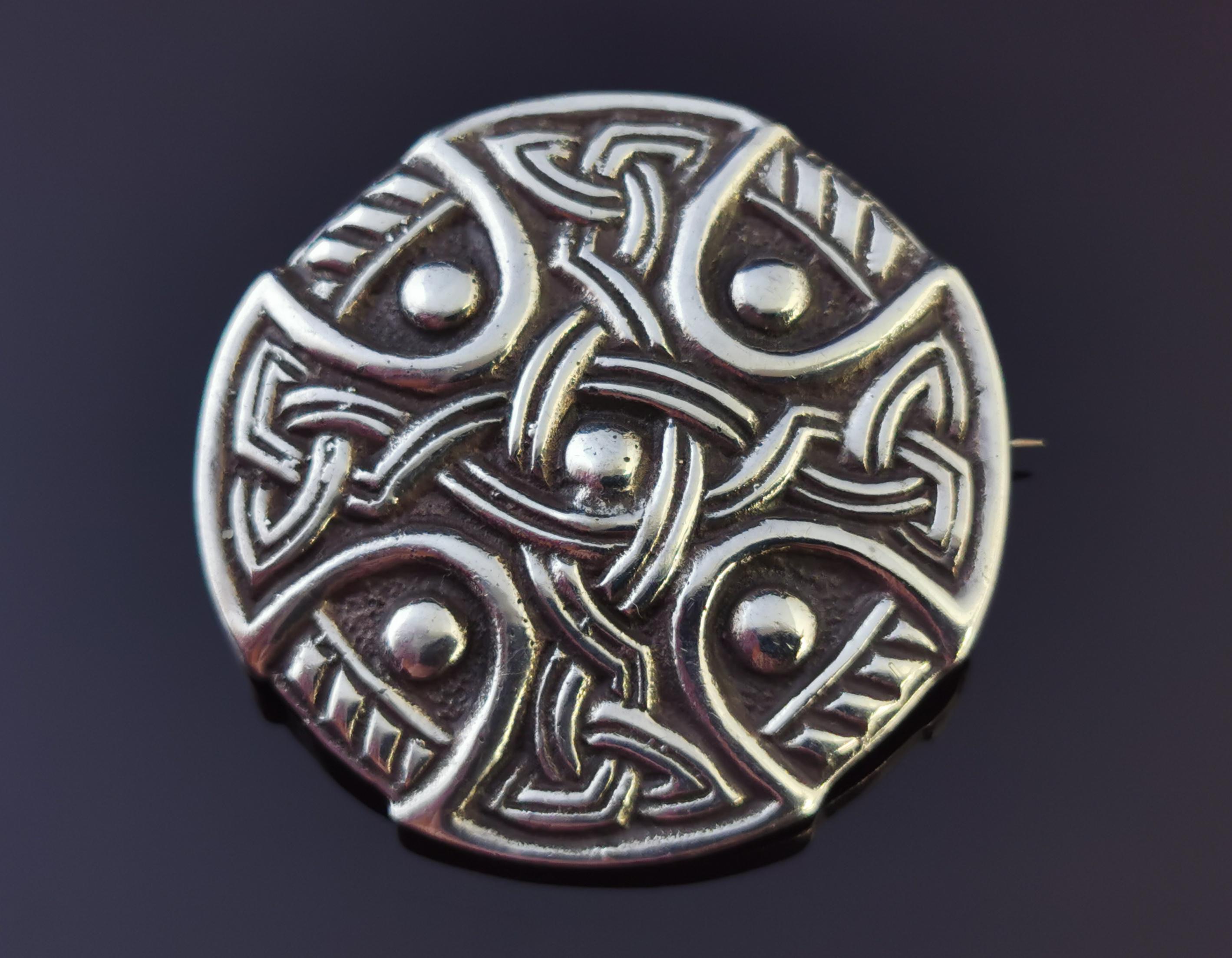 An attractive vintage heavy sterling silver celtic knot brooch.

It is a circular shaped brooch with a knot weave and celtic cross design.

It is marked on the reverse though the marks are worn and hard to see, it has an old C type clasp