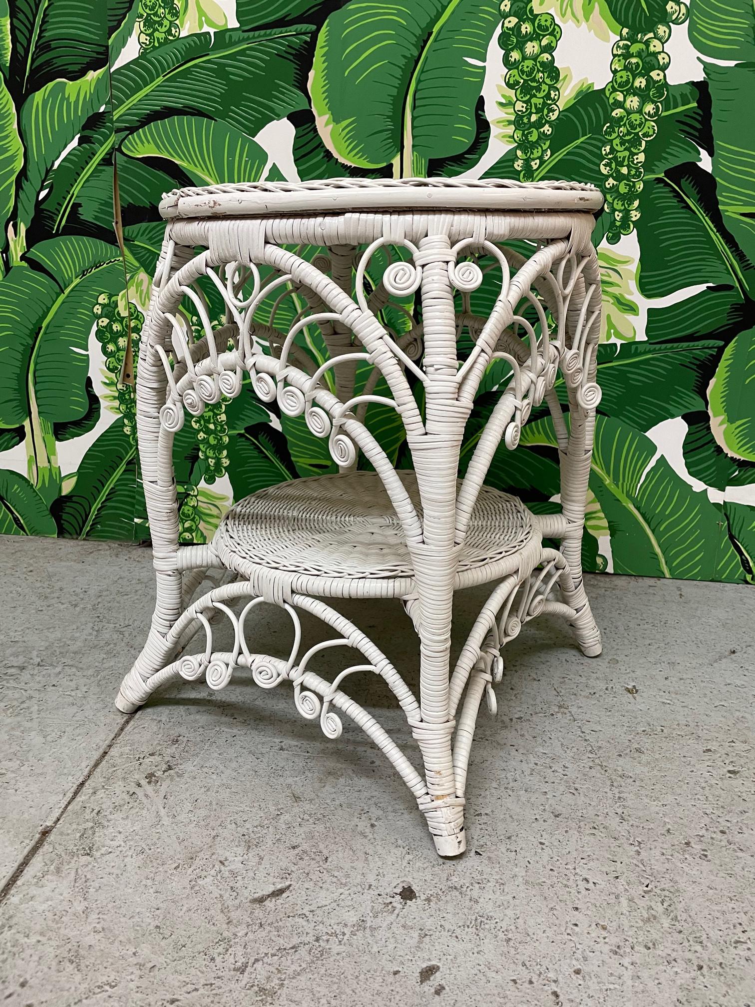 Beistelltisch aus Weidengeflecht im Vintage-Stil mit geflochtener Platte und verschnörkelten und filigranen Schürzen. Mit Rattan umwickelter Rahmen und gespreizte Beine. Nach dem Vorbild von Heywood-Wakefield. Guter Zustand mit kleinen