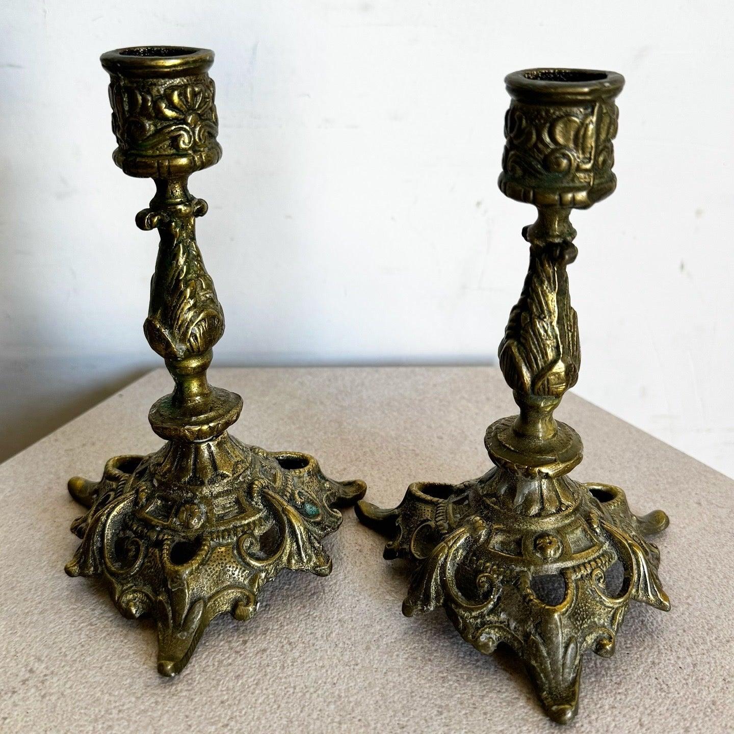 Vintage sculpted brass candlestick holders with intricate designs and warm finish. Exemplifies traditional craftsmanship for timeless sophistication.
 
 We sell items as acquired, without restoring or repairing. Vintage pieces may have age-related