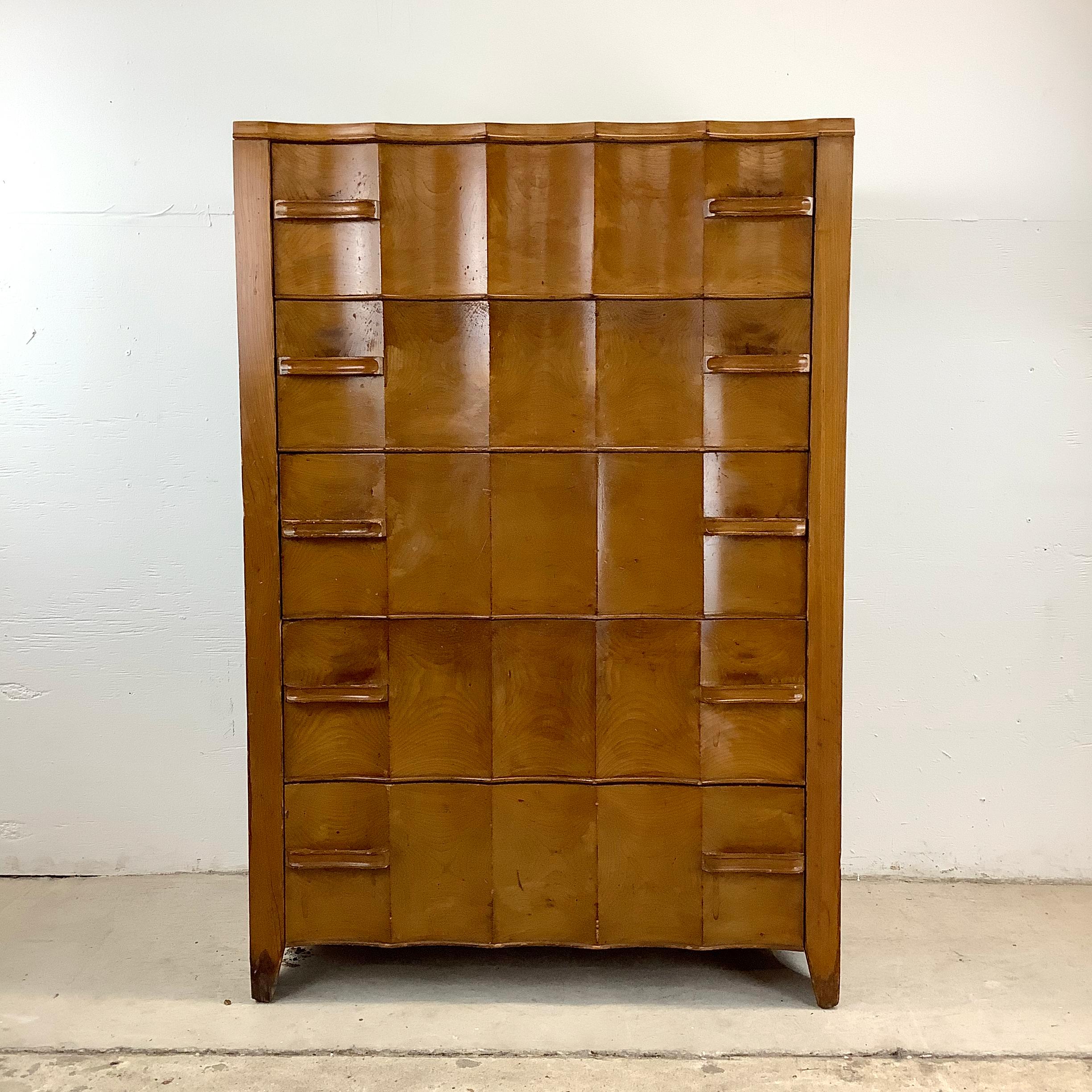 Elevate your interior décor with the timeless elegance of this vintage highboy dresser, a true testament to early 20th century deco design. Crafted with meticulous attention to detail, this stunning piece features distinctive sculptural drawer