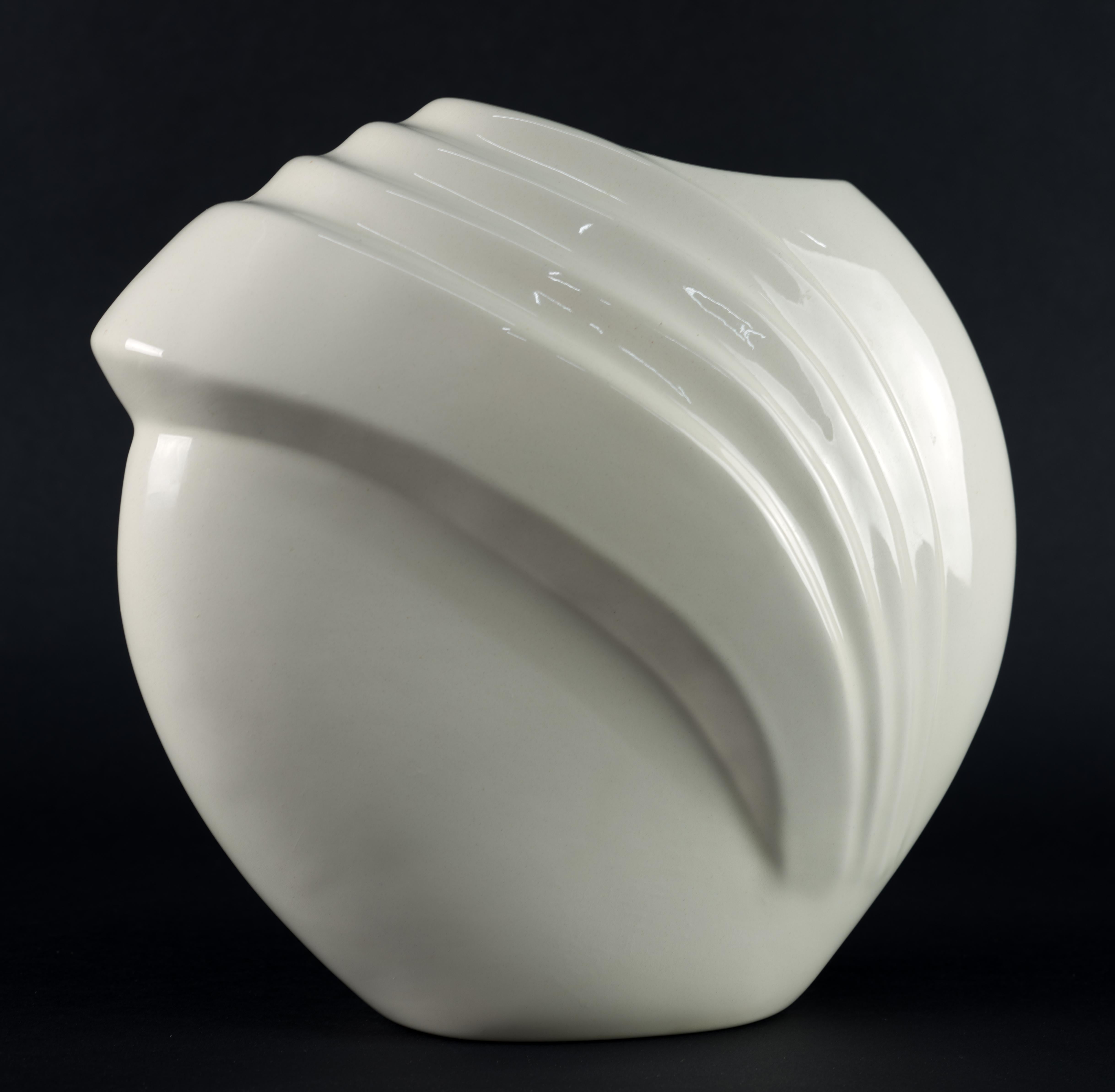 Vintage vase in Art Deco style has rounded profile with pronounced, asymmetrical graphic relief, creating an upwards movement and visual interest. The relief continues on the back side of the vase. The vase is decorated with high shine off-white