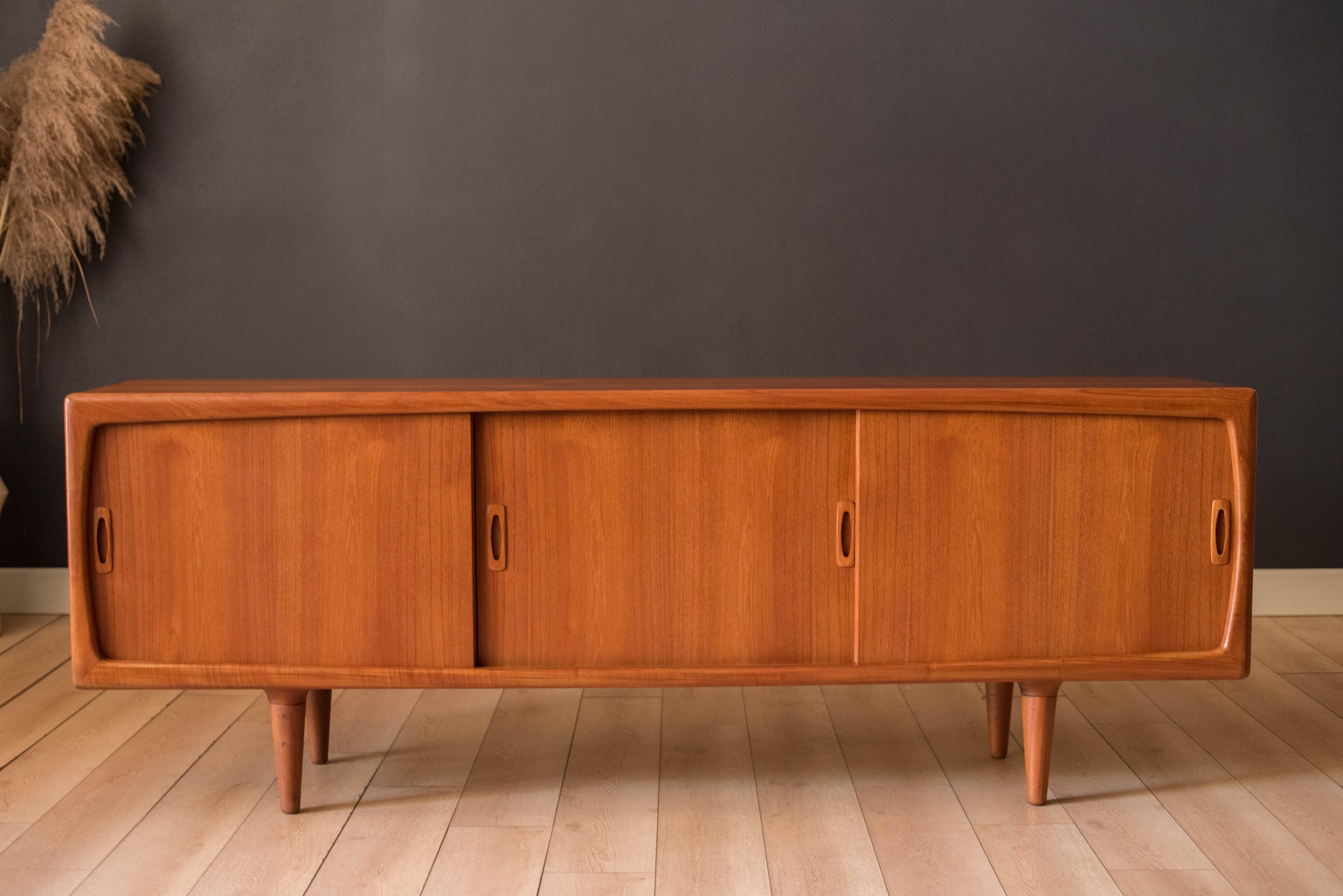 Credenza credenza del Mid Century Modern di H. A. Hansen in teak, anni '60 circa, prodotto in Danimarca. Questo pezzo da vetrina è caratterizzato da ante scorrevoli accessoriate con maniglie scultoree. Offre una grande quantità di spazio, tra cui